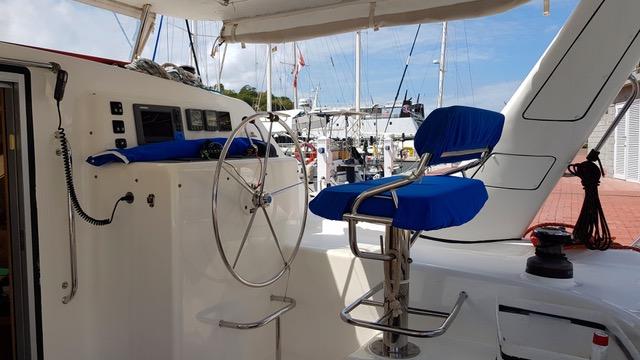 Cockpit of 2010 Admiral 38 Executive yacht with blue seating and steering wheel.