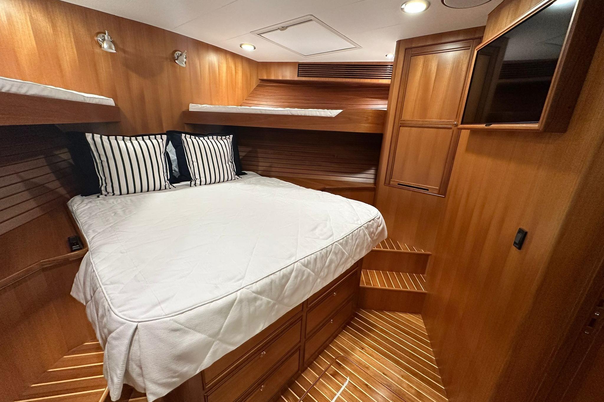Luxurious cabin interior of 2023 Marlow Explorer 66E-CB with wood finish and cozy bedding.
