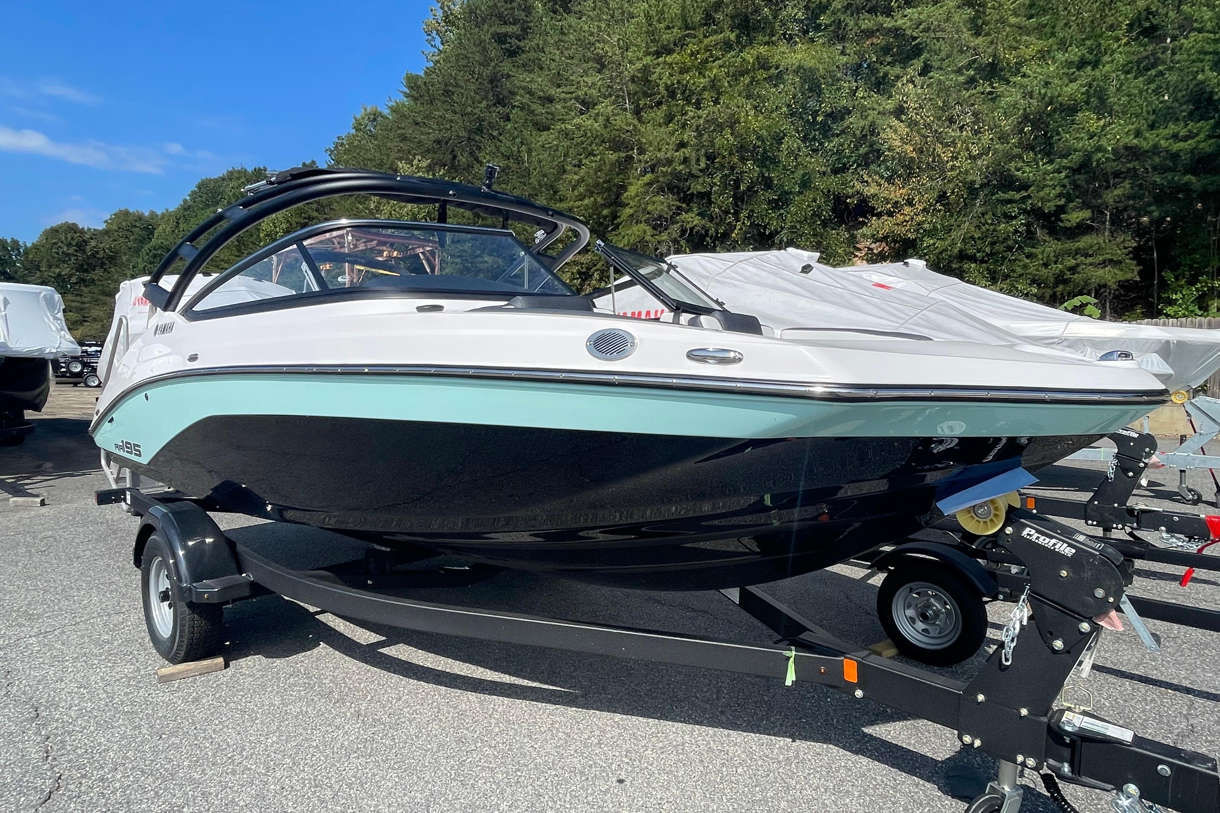 2026 Yamaha Boats AR195 on trailer, parked outdoors with trees in background.