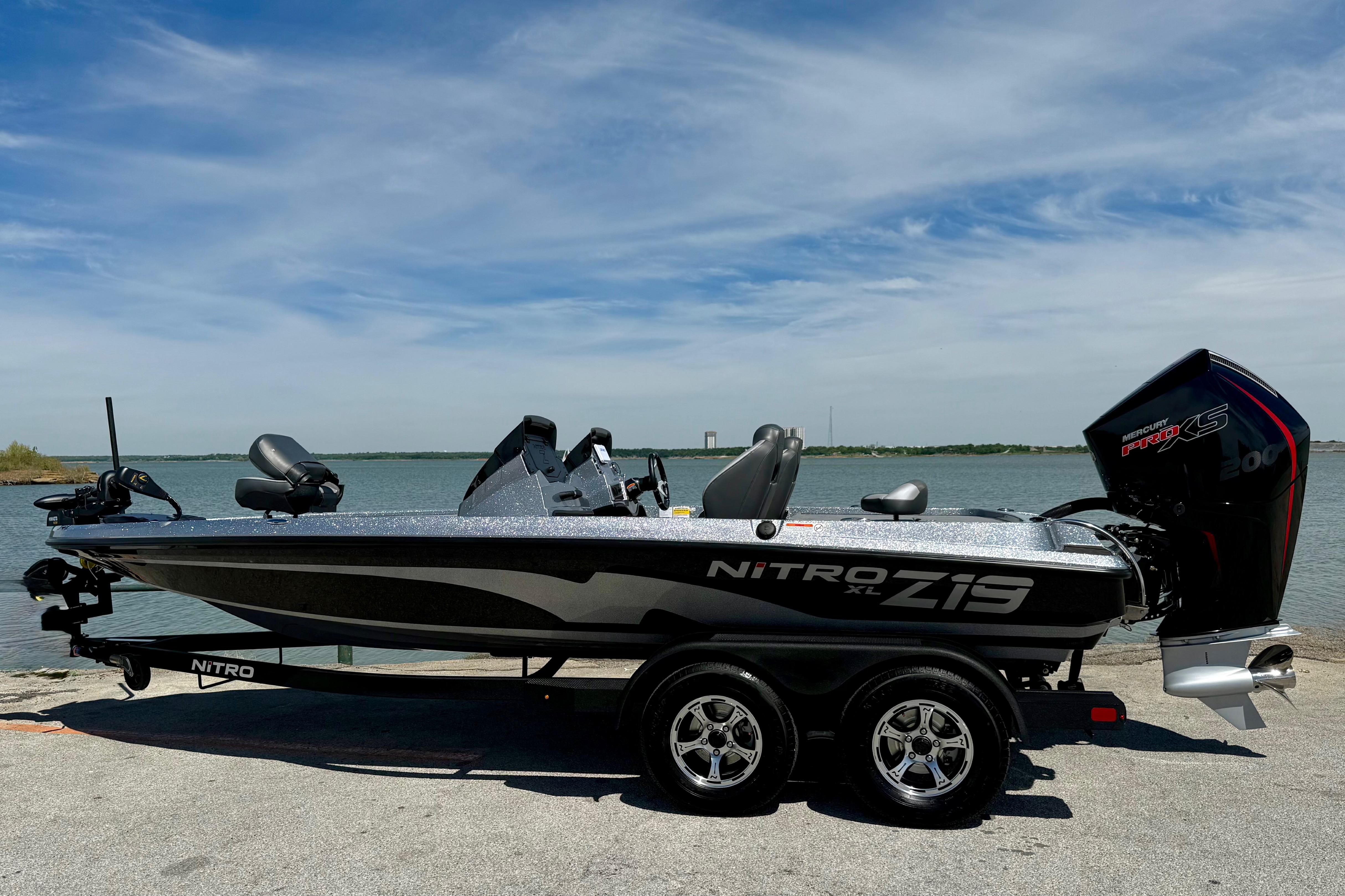 2026 Nitro Z19 XL boat on trailer by a lake under a clear sky.