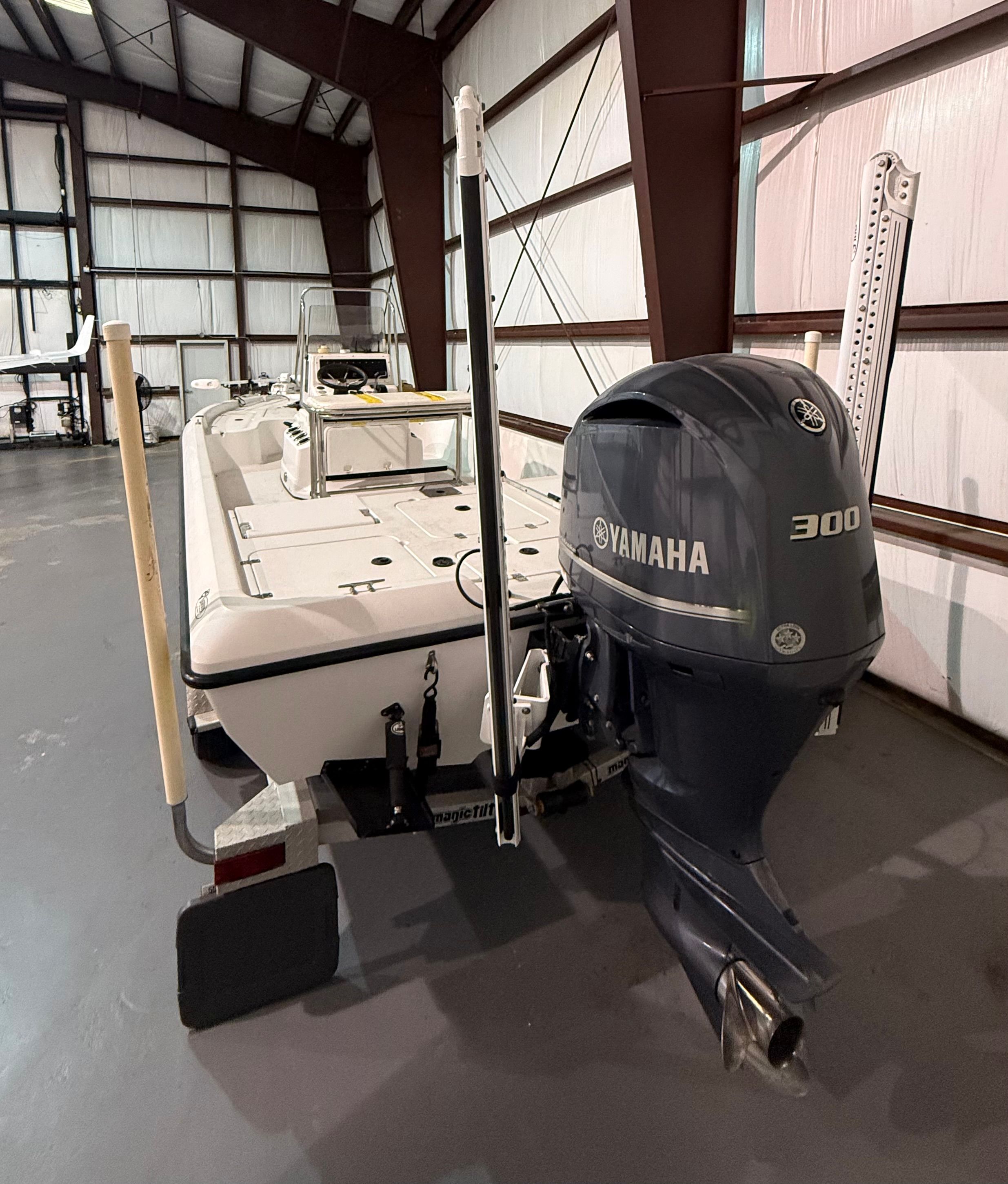 A 2004 Champion 24 Bay Champ boat with a Yamaha 300 outboard motor in a storage facility.