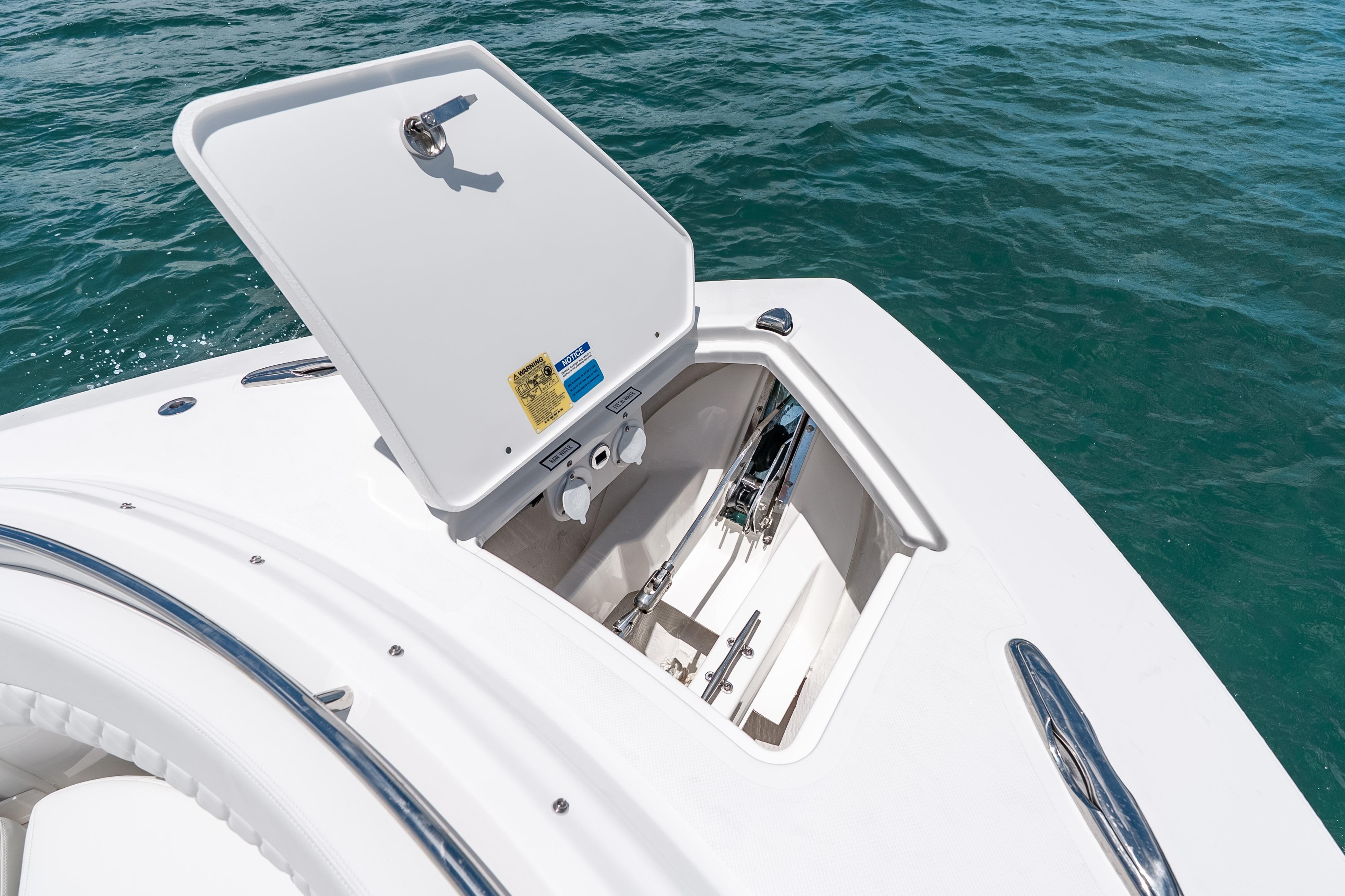 2026 Pursuit DC 326 Dual Console boat with open storage compartment on calm water.