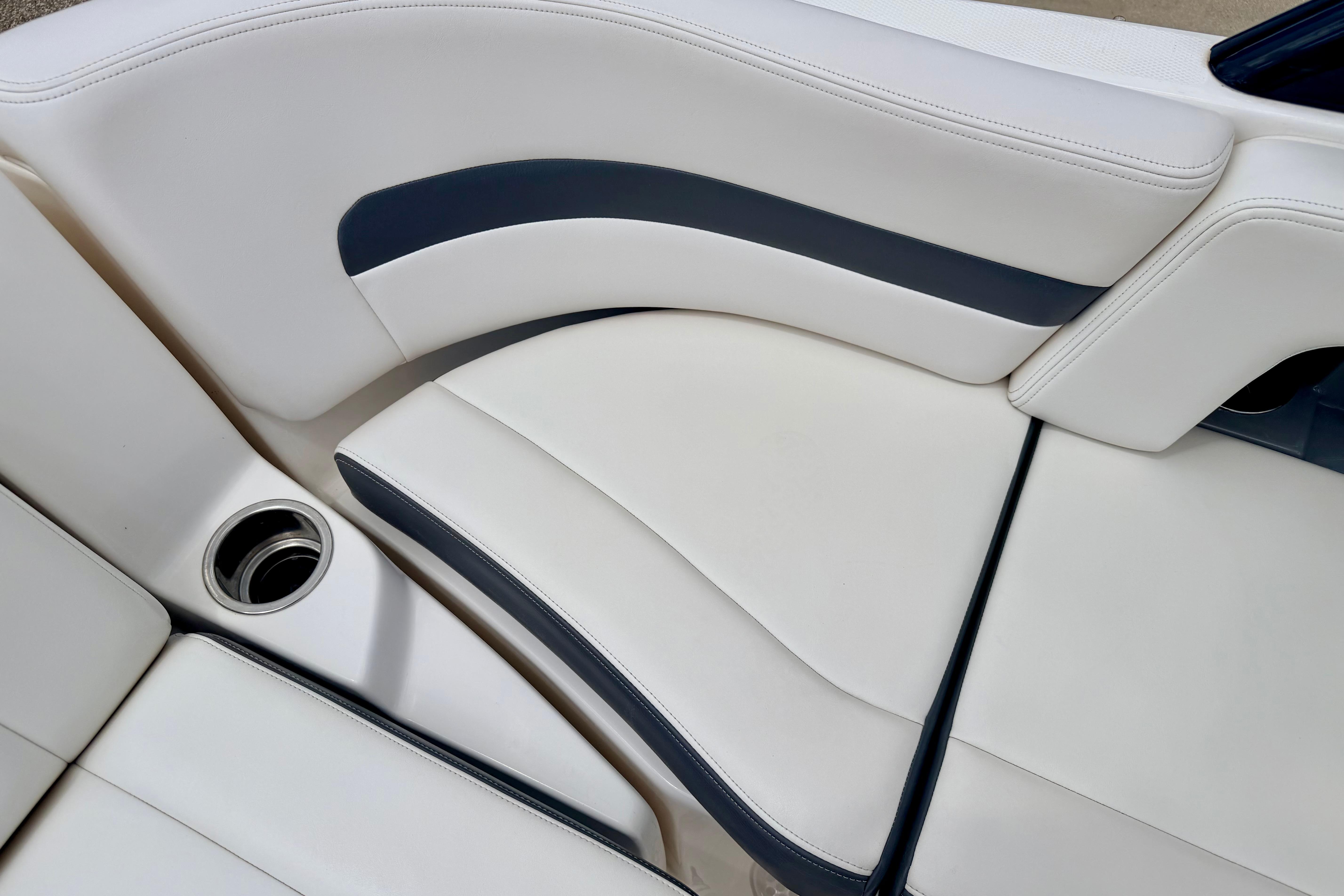 2015 Chaparral Sunesta 264 boat interior with white and navy seating and cup holder.