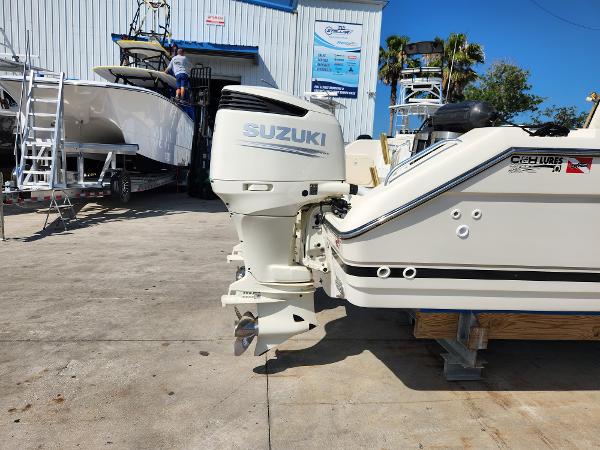 2005 Pursuit 3070 Offshore Center Console with Suzuki outboard motor in a boatyard.