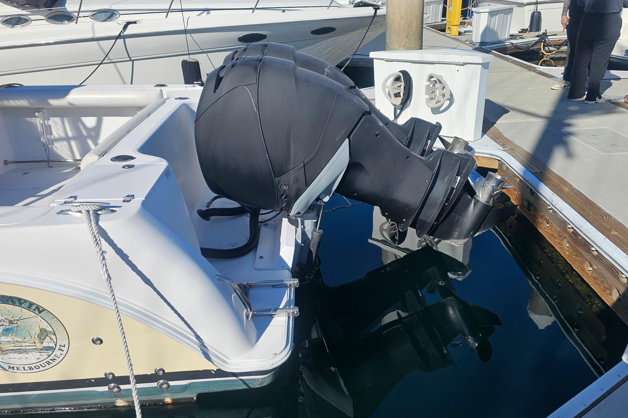 2006 Pro-Line 32 Express boat with outboard motor docked at marina.