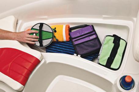 Storage compartment in a 2012 Tahoe Q4 SS boat with colorful bags and towels.