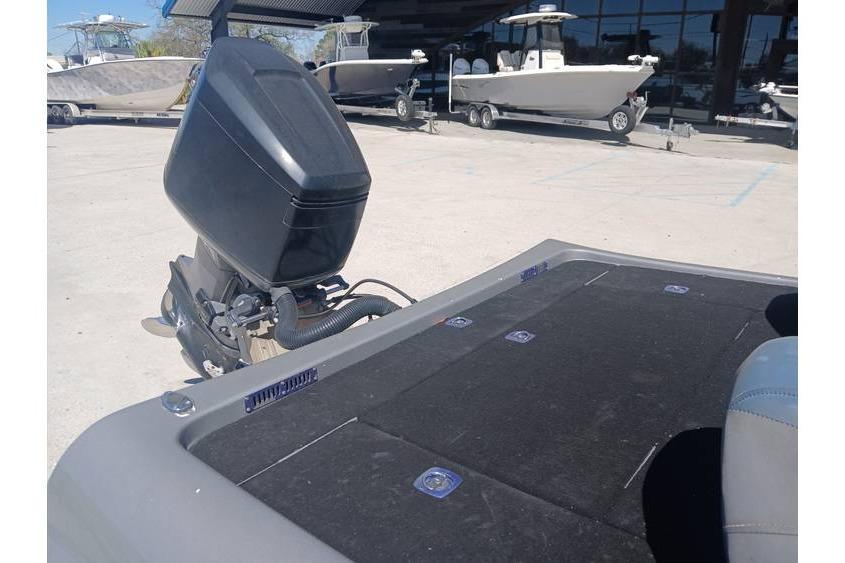 1994 Gambler 21 boat with outboard motor, parked near other boats in a marina.