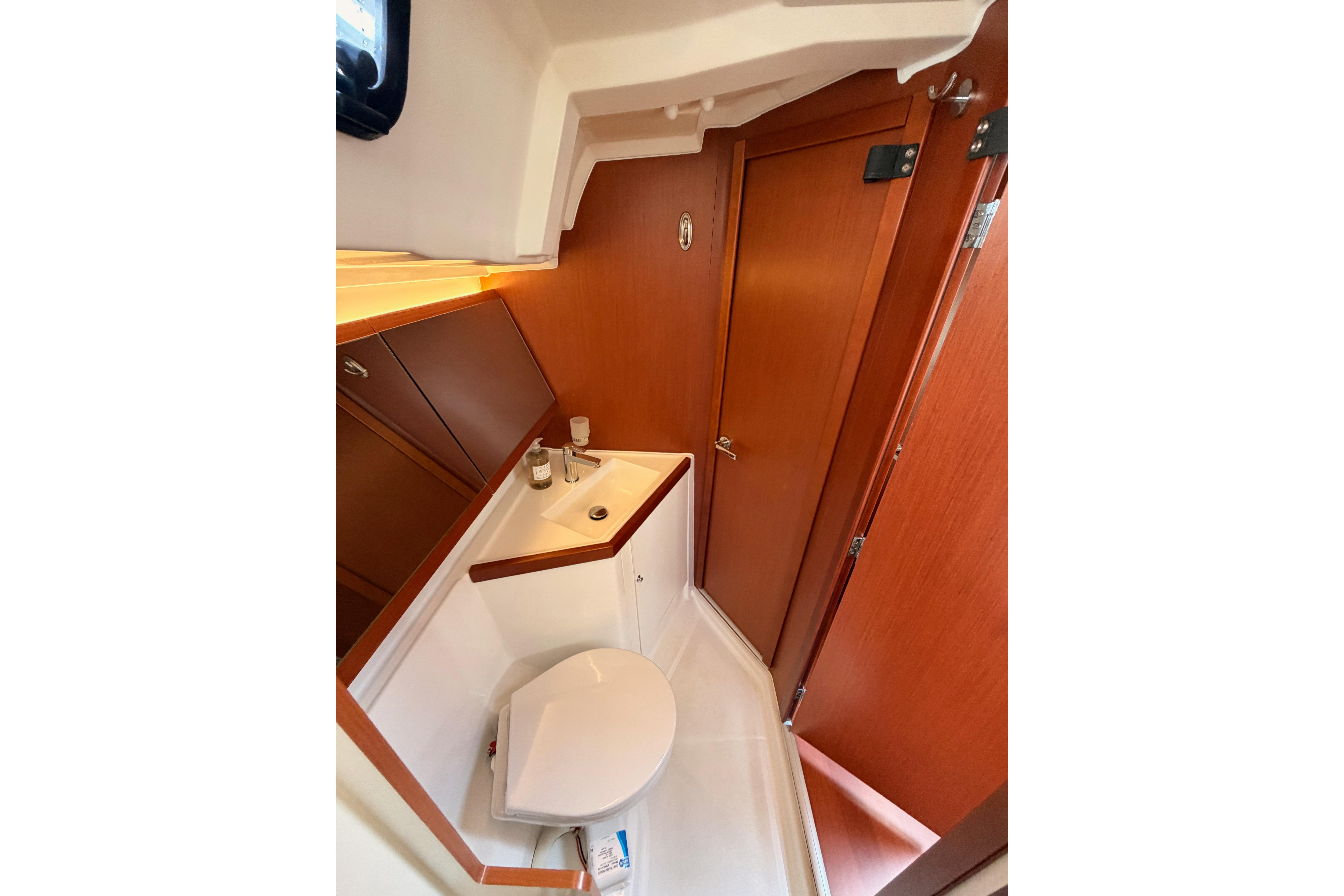 Beneteau Oceanis 46.1 2020 yacht bathroom with wooden cabinetry and compact design.