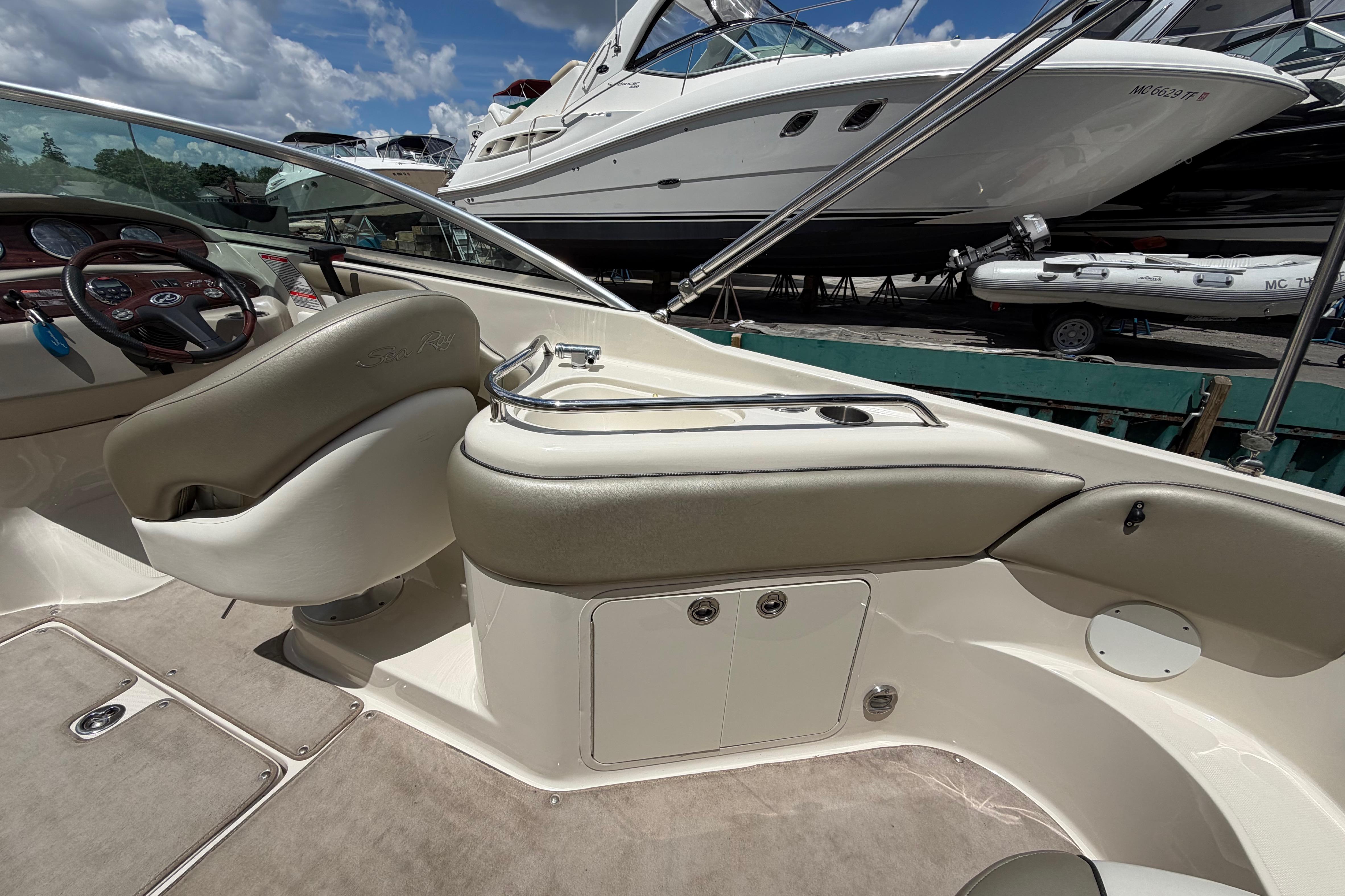 2004 Sea Ray 240 Sundeck interior with helm, seating, and dashboard under a sunny sky.