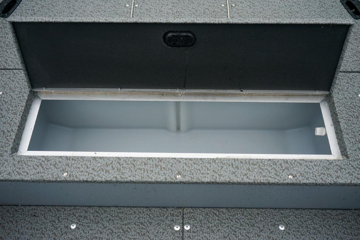 Open storage compartment in 2026 Lund 1400 Fury Tiller boat, showcasing interior space.