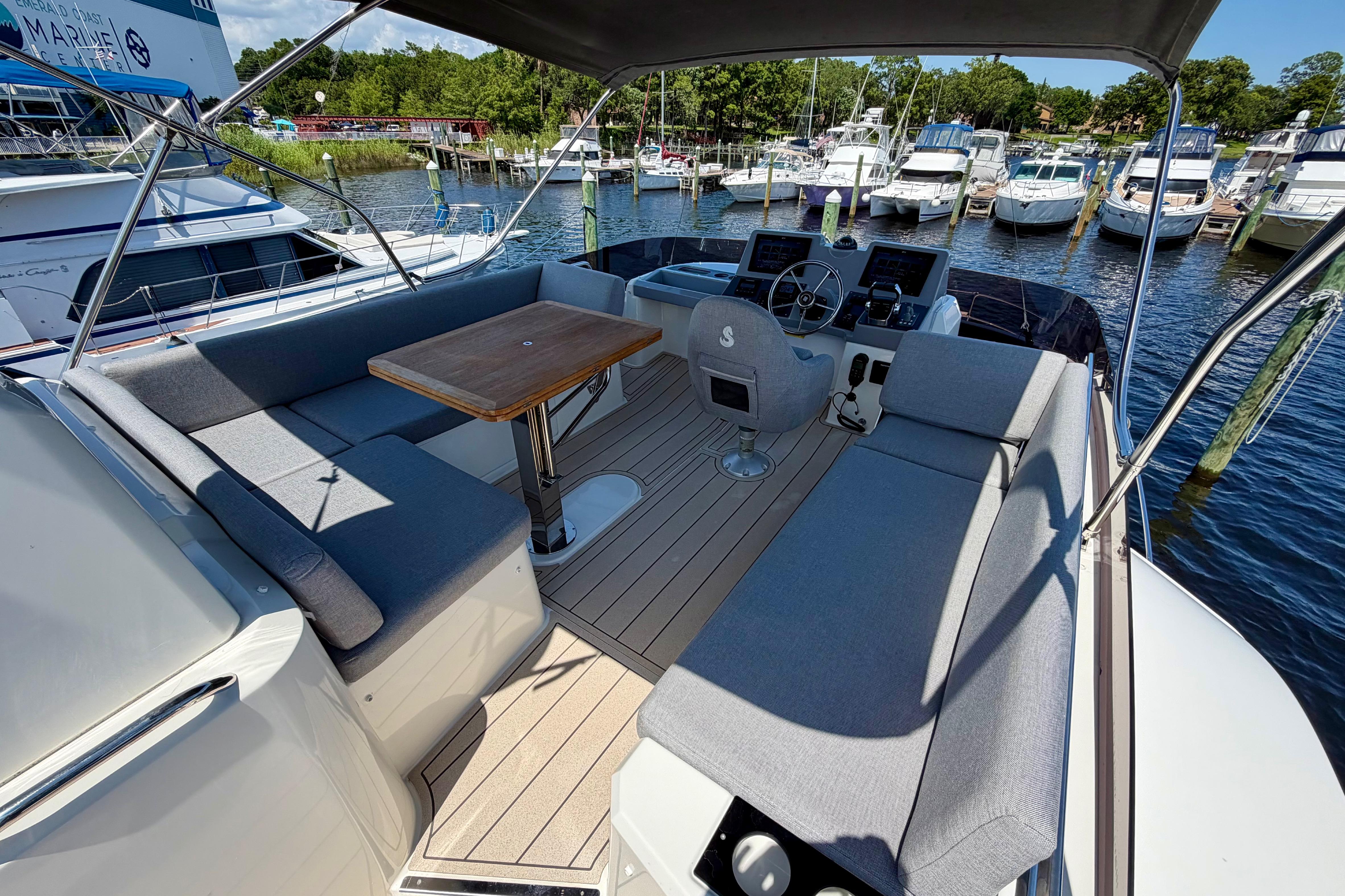 2025 Beneteau Swift Trawler 41 Flybridge with seating and helm, docked at marina.