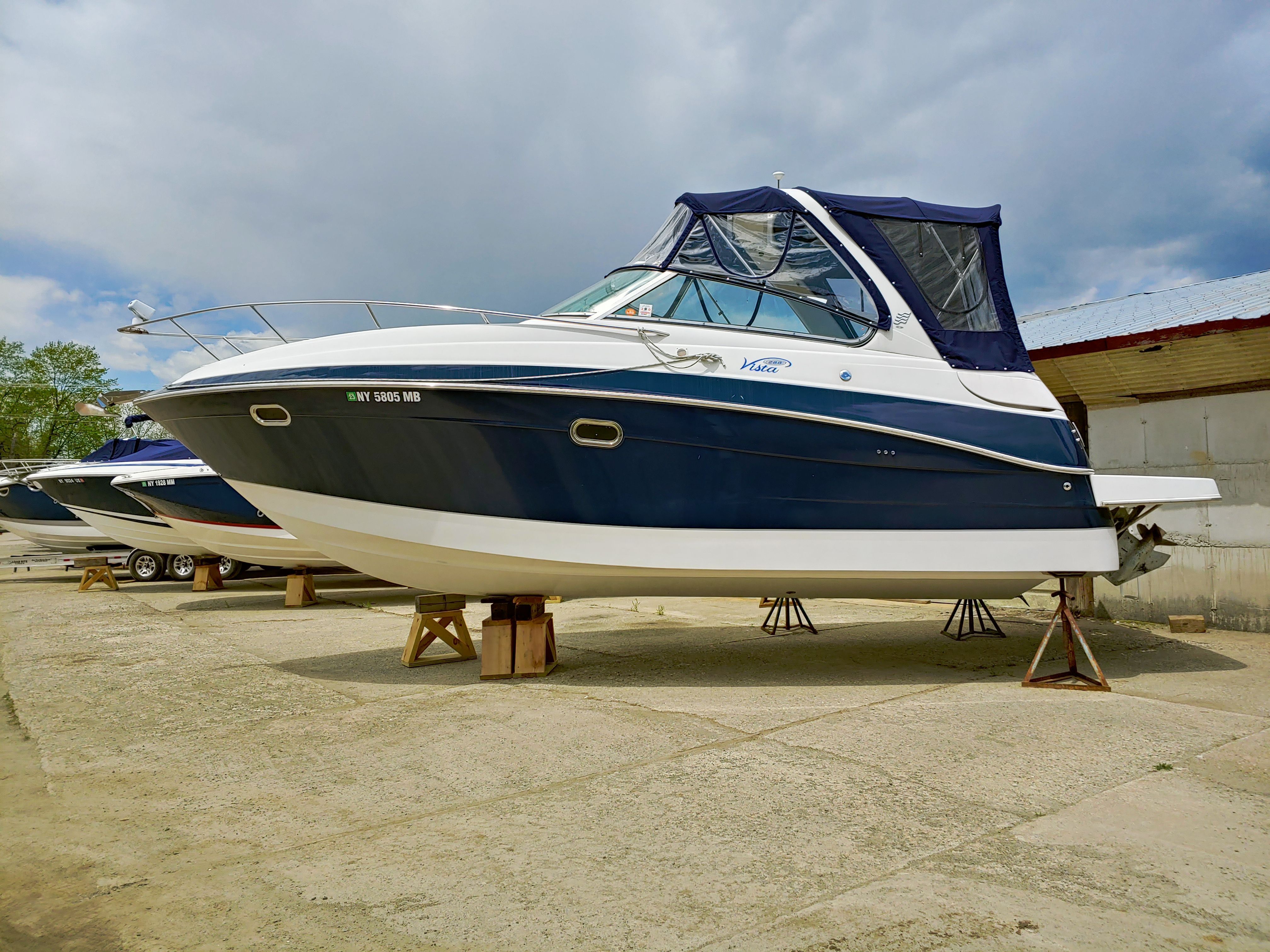 A blue and white boat is on stands, out of the water.