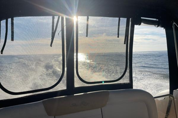 Interior view from a 2008 Sea Ray 330 Sundancer boat, overlooking the ocean at sunset.