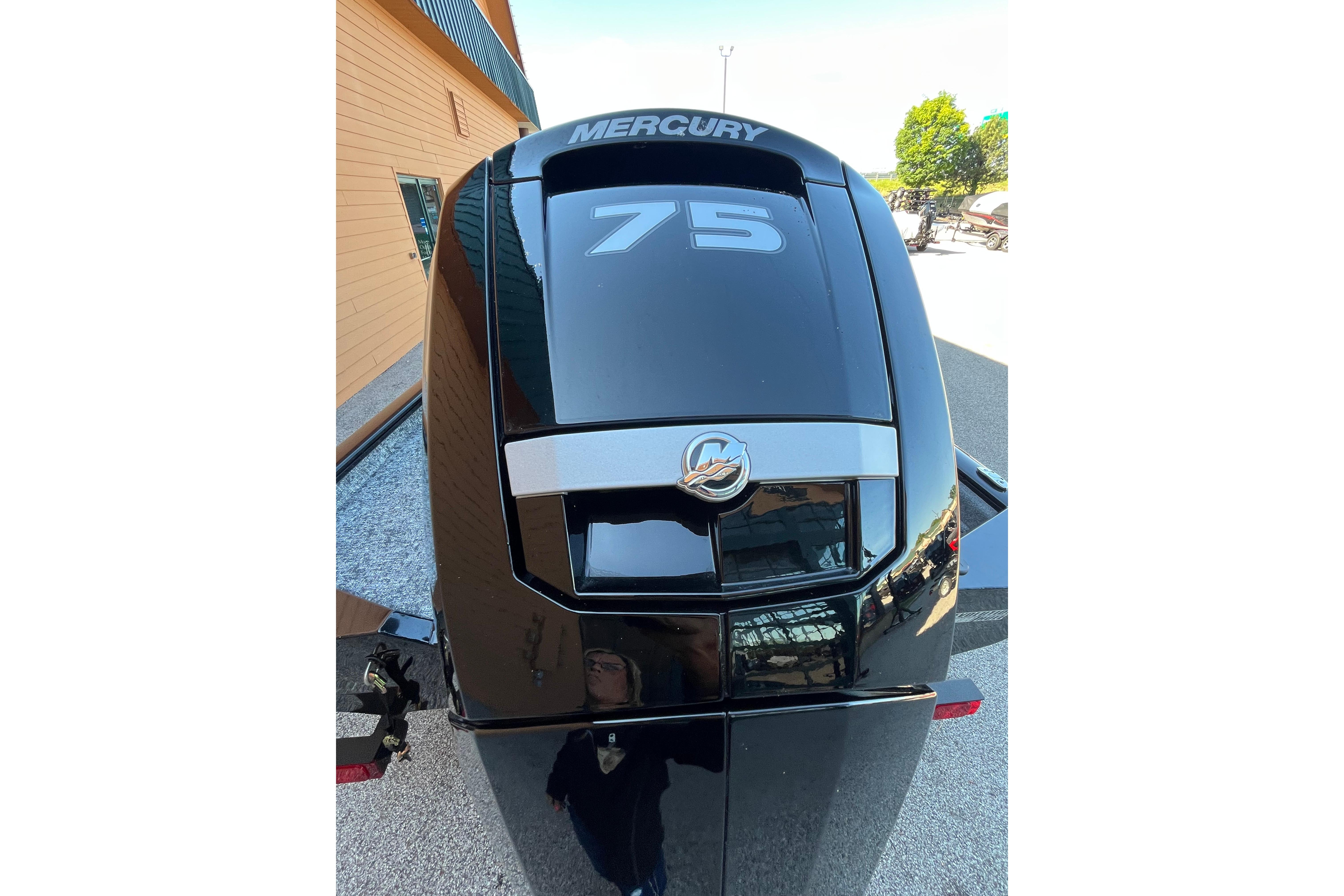 Mercury 75 outboard motor on 2026 Tracker Pro Team 175 boat, parked outdoors.