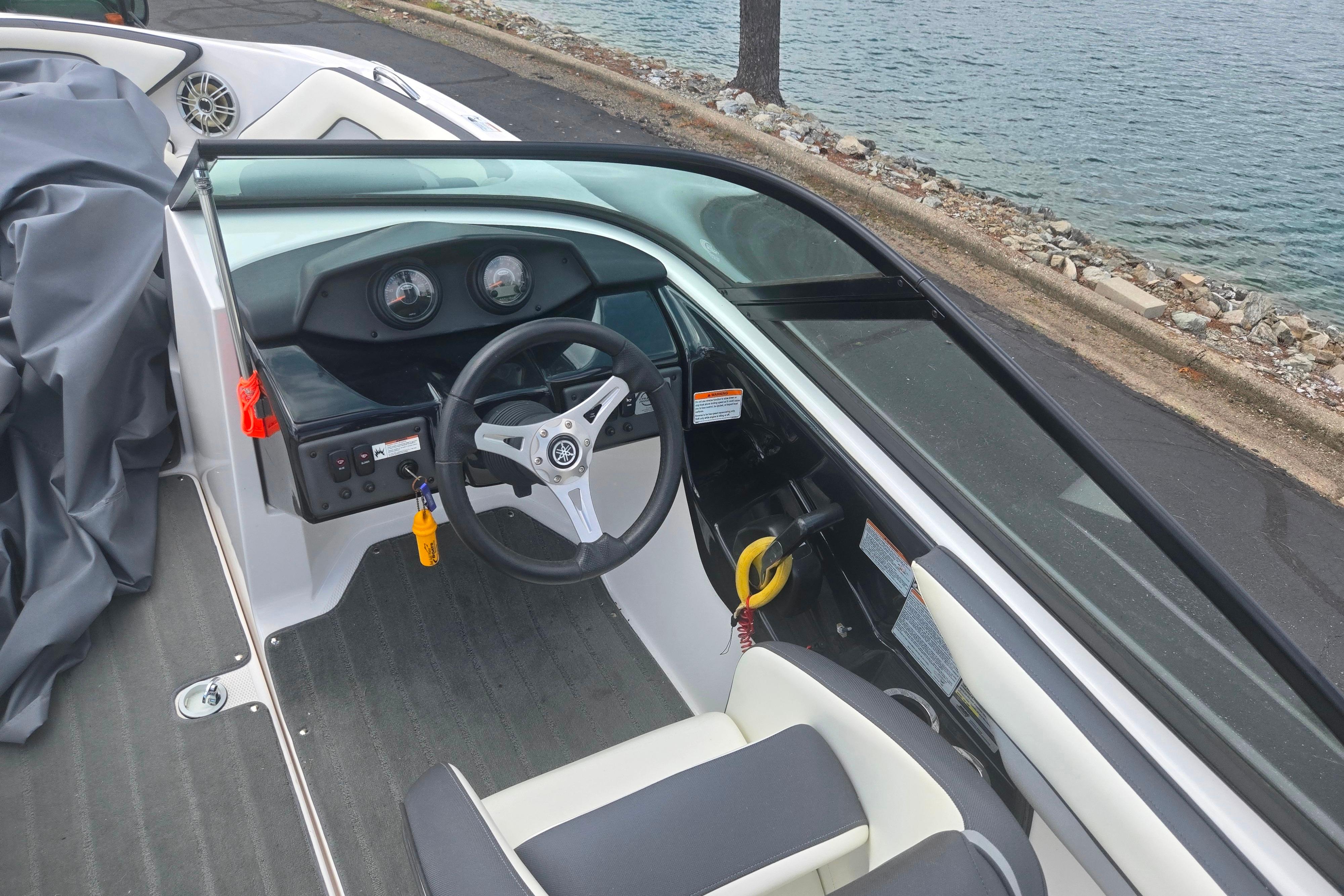 2016 Yamaha Boats AR192 cockpit with steering wheel and dashboard by the water.