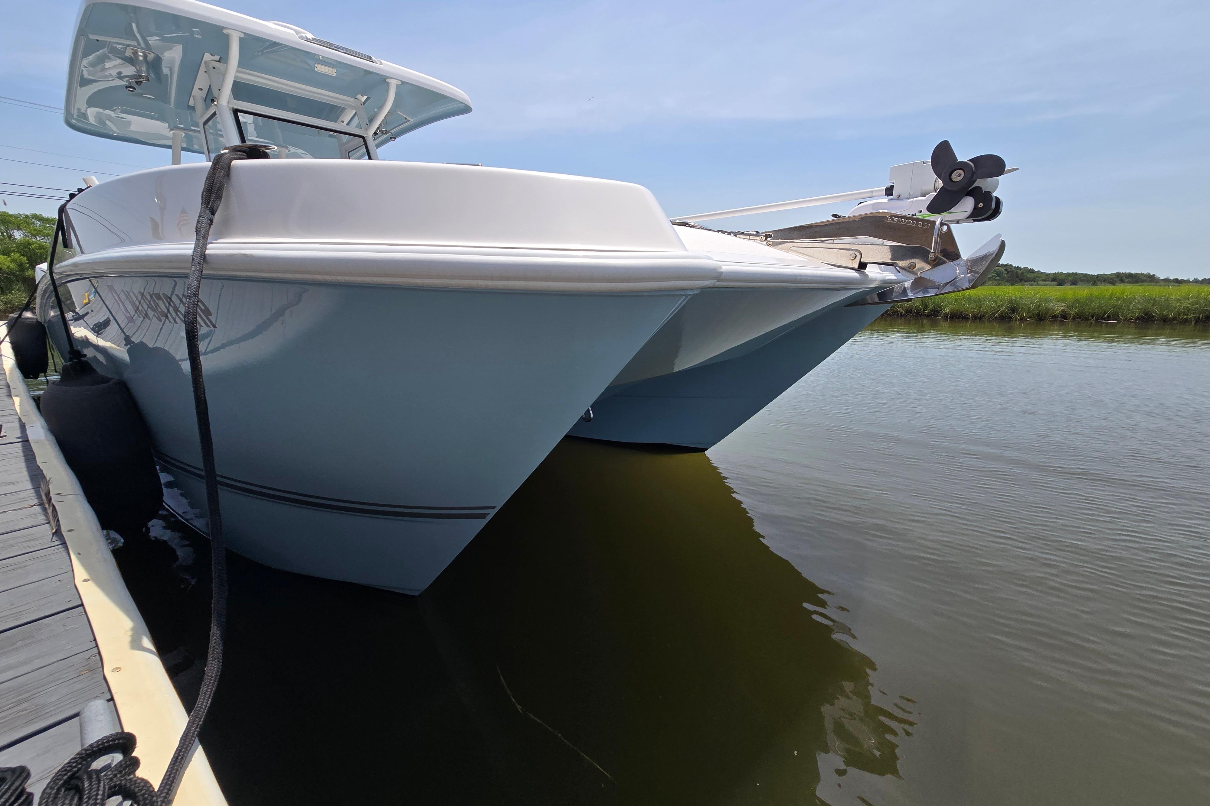 2021 Twin Vee 280 GFX CC catamaran docked on calm water.