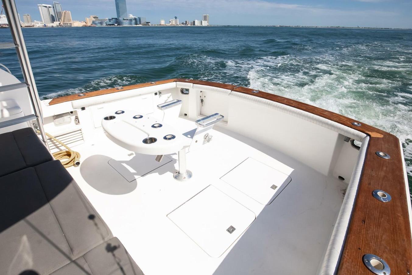 1999 Ocean Yachts 48 Super Sport cruising with city skyline in background.