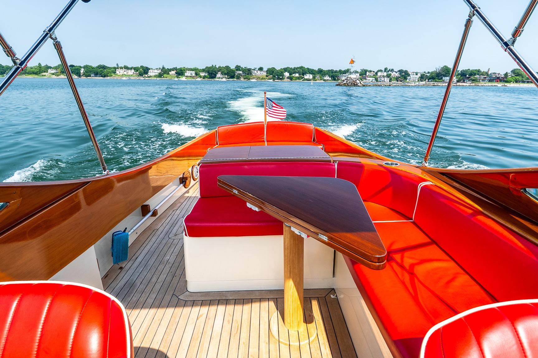 2005 Hinckley Talaria 29R boat with red seating, cruising on a sunny day.