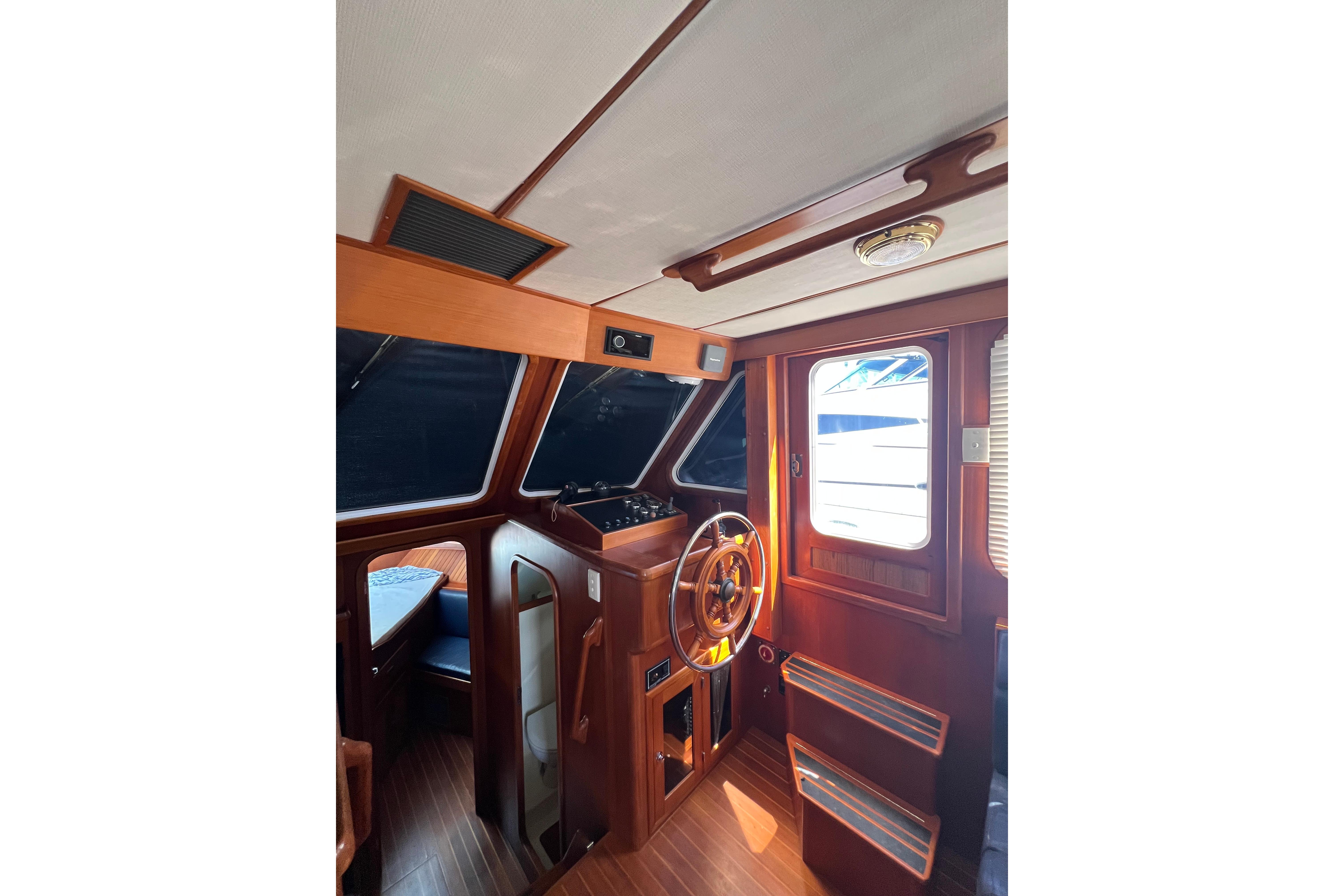 Interior of 2007 Heritage East 36 Sundeck Trawler with wooden helm and seating area.