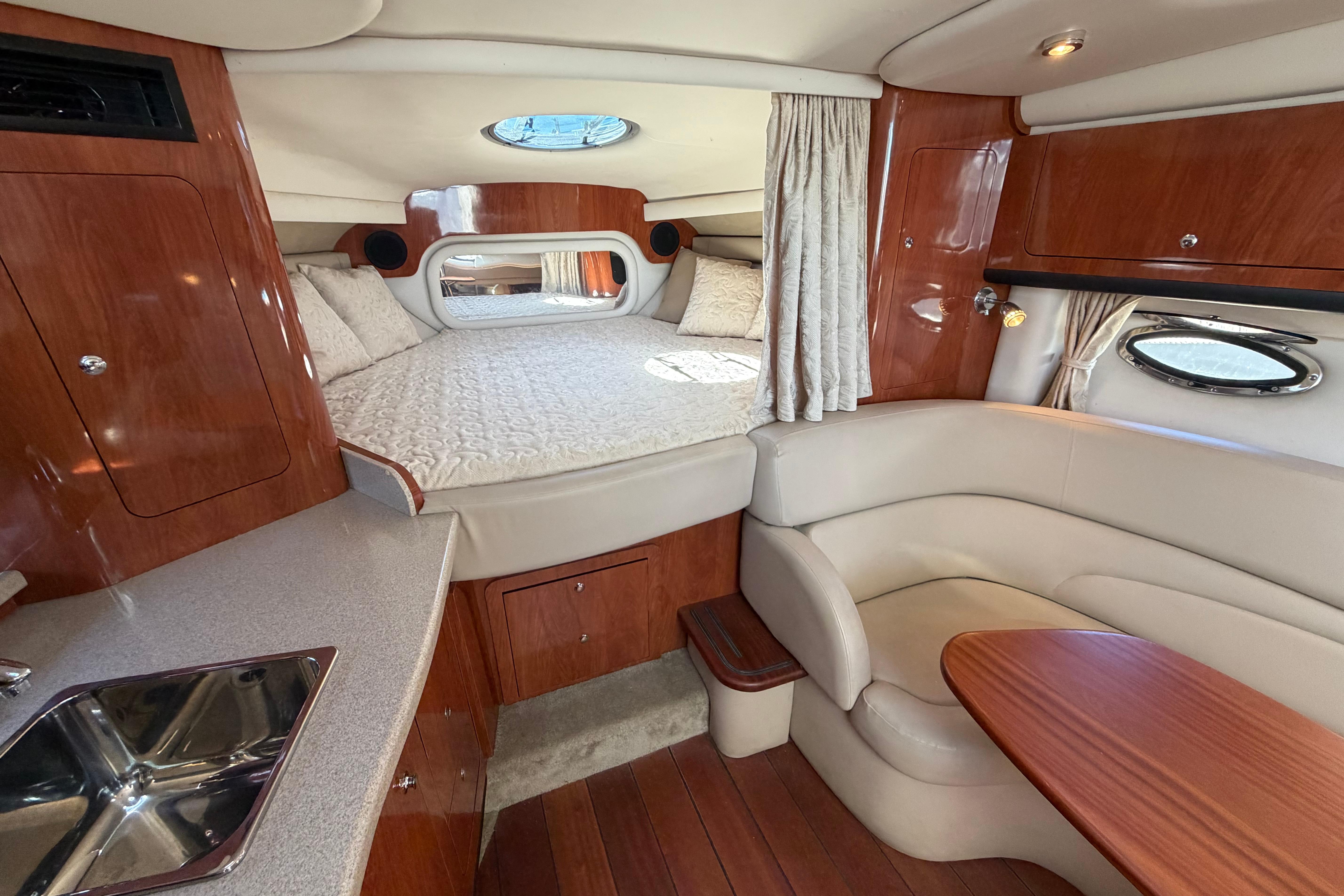 Luxurious interior of a 2008 Crownline 340 CR yacht with cozy bed and seating area.