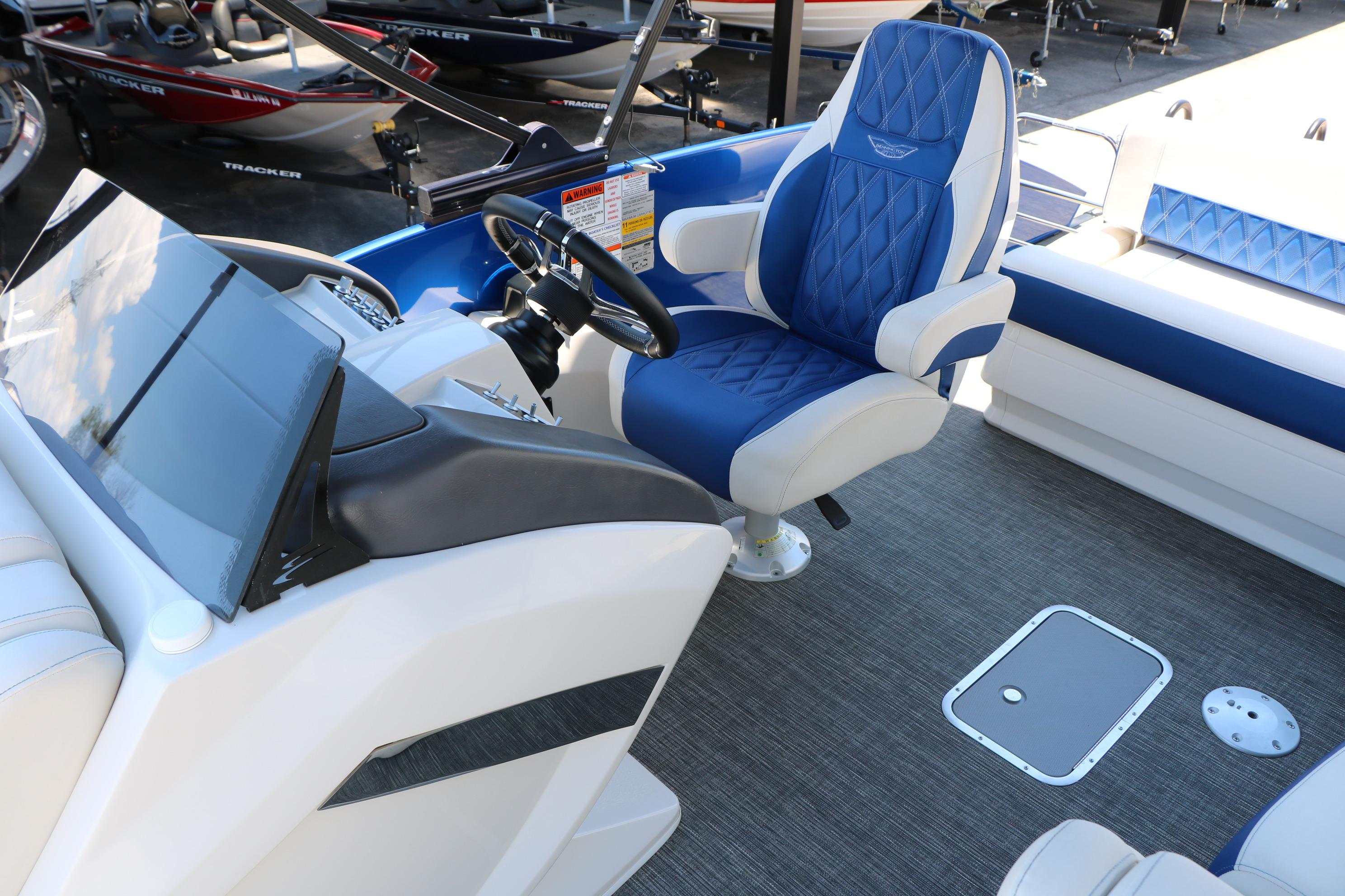 2024 Bennington 23 RX Swingback boat interior with blue and white seating and modern dashboard.