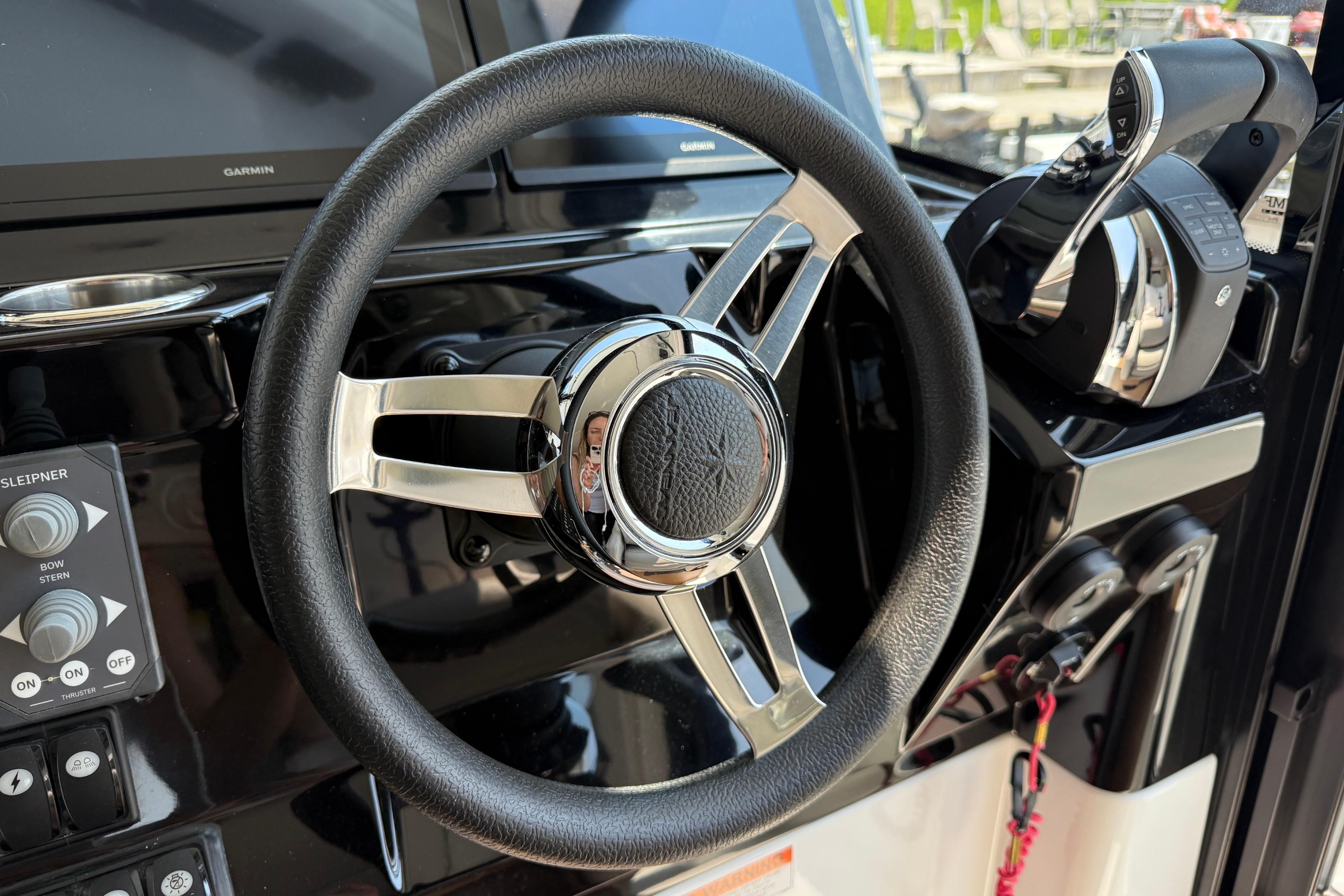 Steering wheel and controls of 2022 Jeanneau NC 1095 Fly boat cockpit.