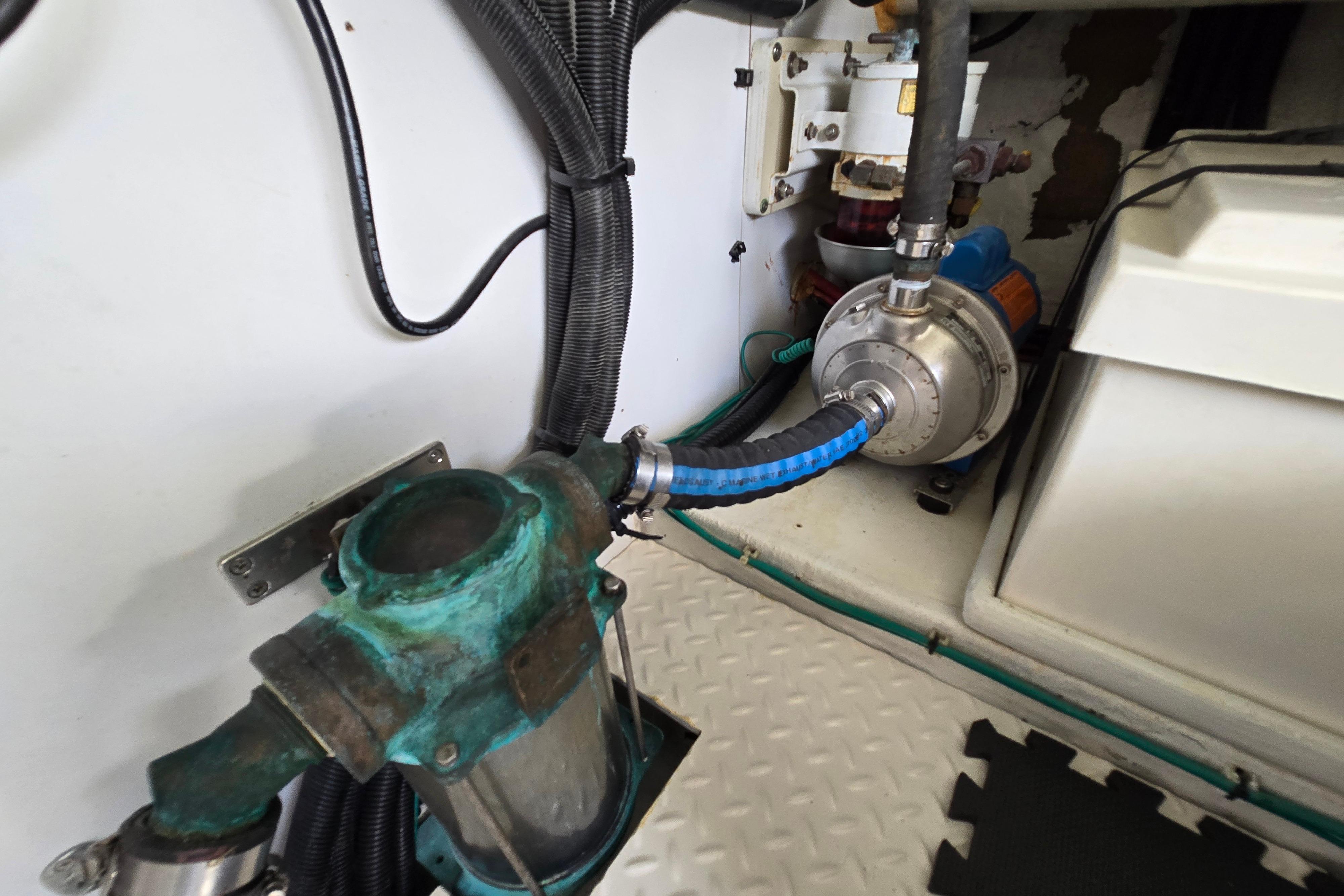 Engine room of 2004 Grand Harbour 58 yacht, featuring mechanical components and hoses.