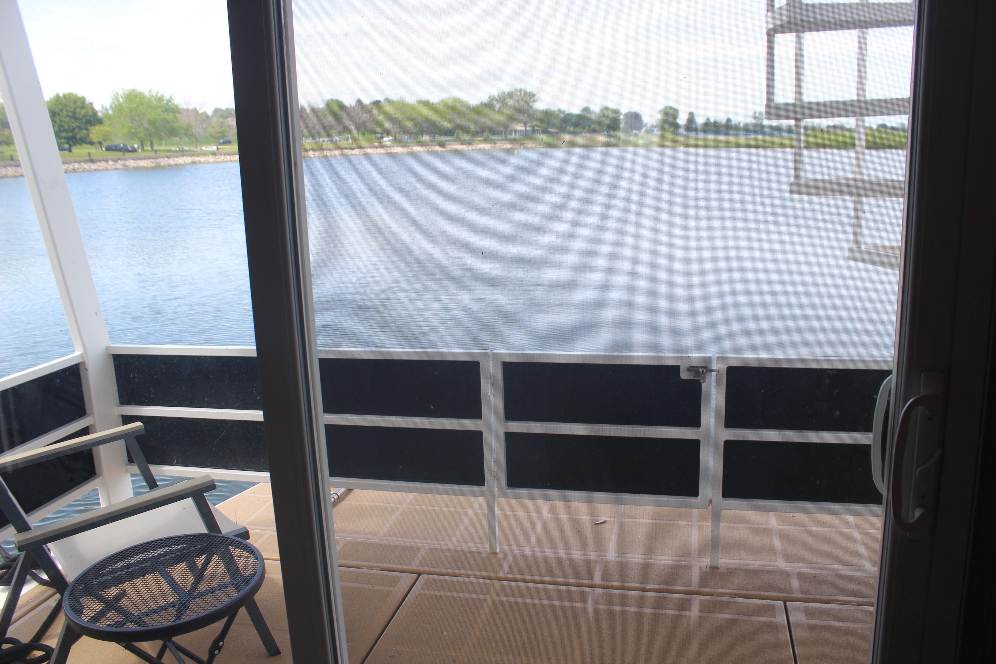 View from Skipperliner 480 Flybridge 2010, overlooking serene lake and lush greenery.