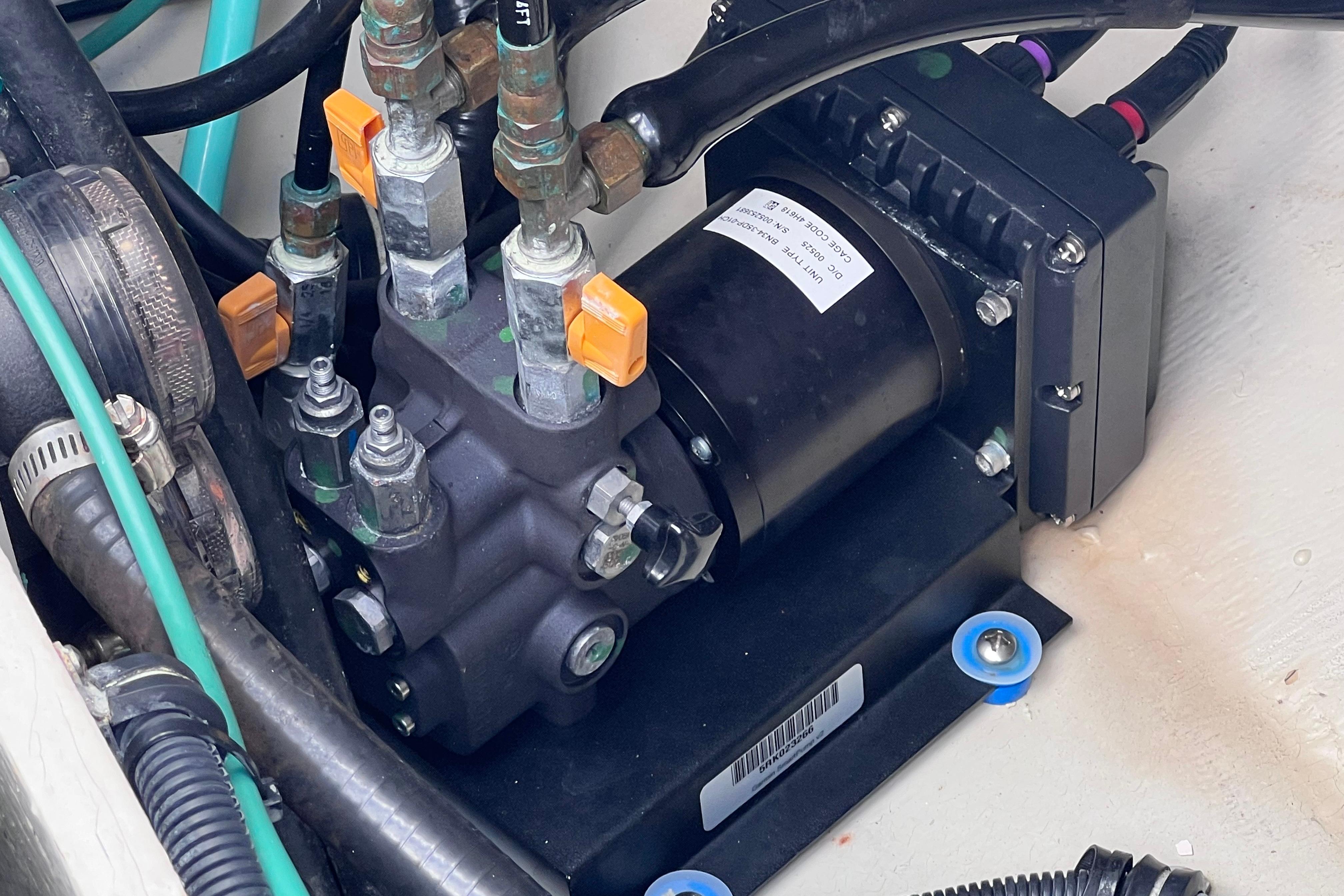 Hydraulic system components in a 2004 Pursuit 2870 Walkaround boat engine compartment.