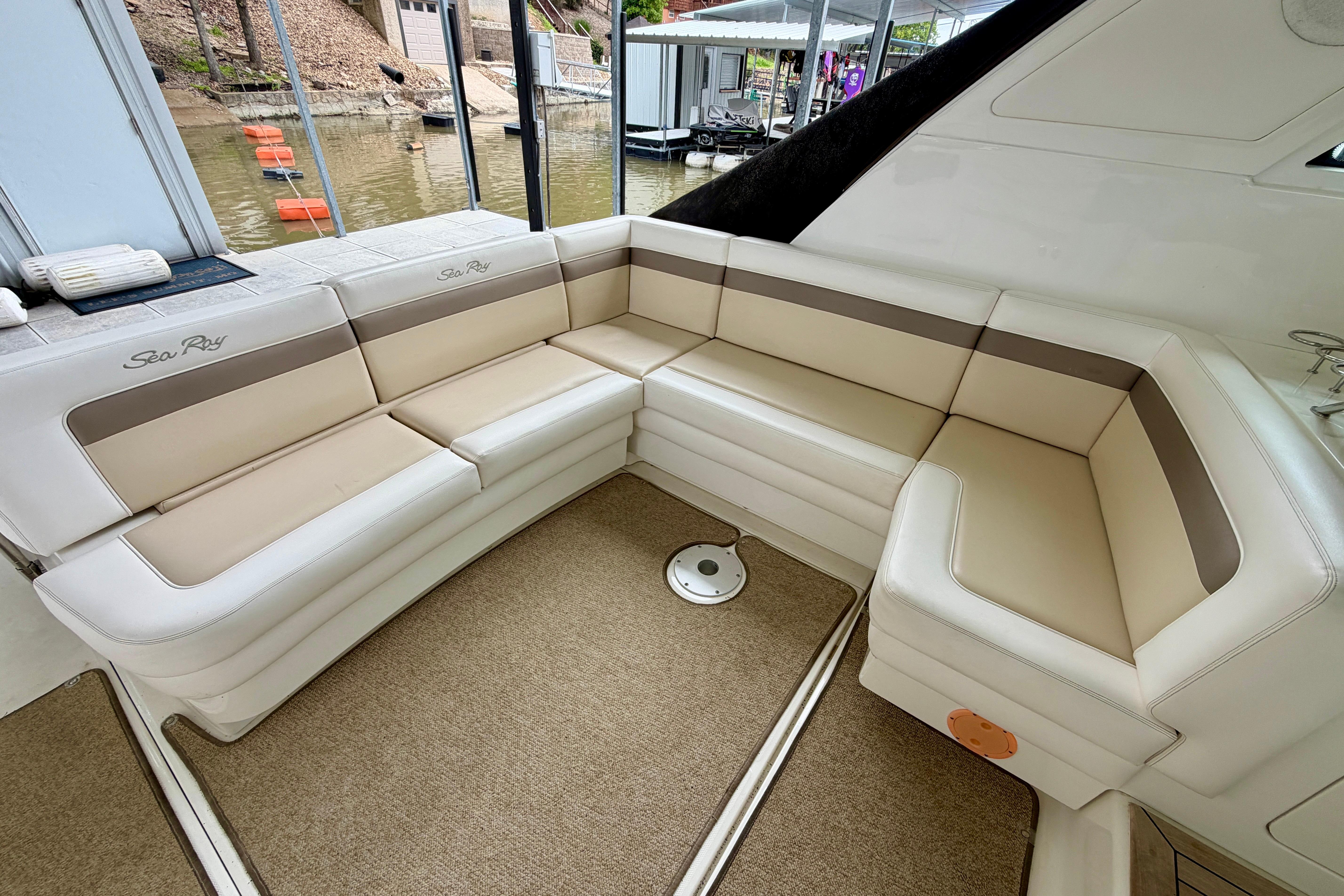 Luxurious seating area on a 2012 Sea Ray 450 Sundancer yacht, docked by the water.