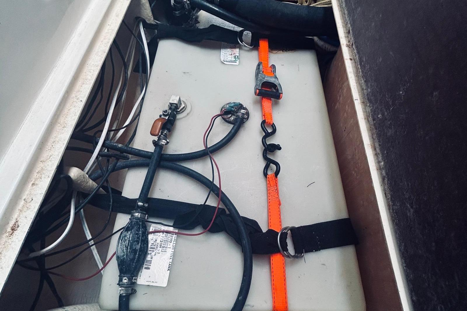 Battery compartment of a 2001 Robertson & Caine Leopard boat, featuring secured wiring and straps.