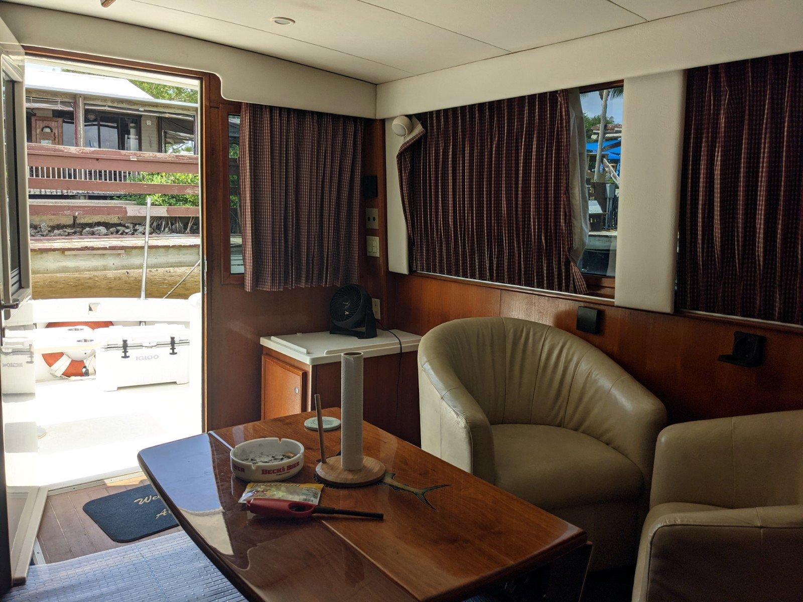 Interior of 1977 Hatteras 46 Convertible yacht with cozy seating and wooden table.