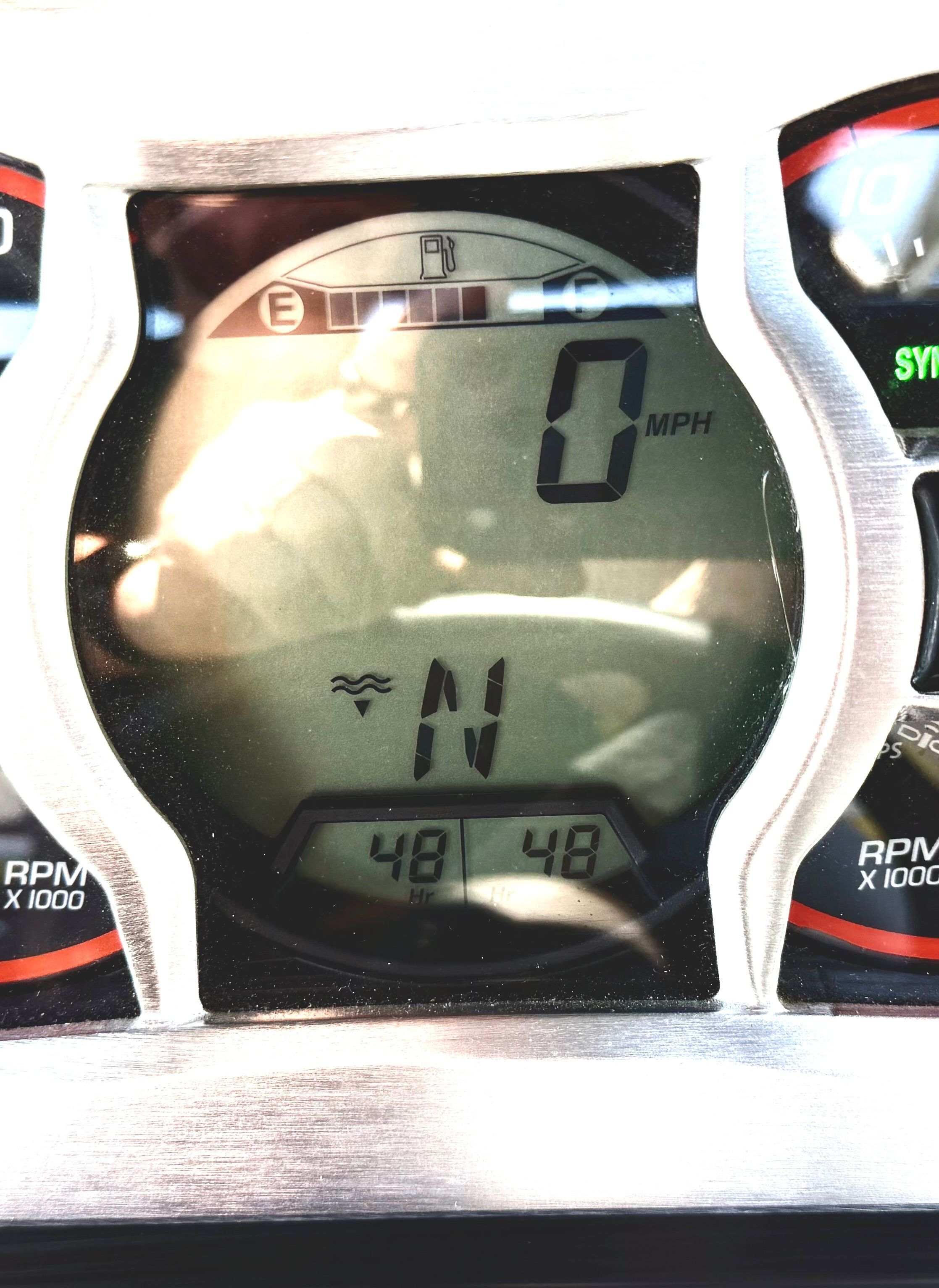Close-up of a boat dashboard with digital display showing speed and direction.