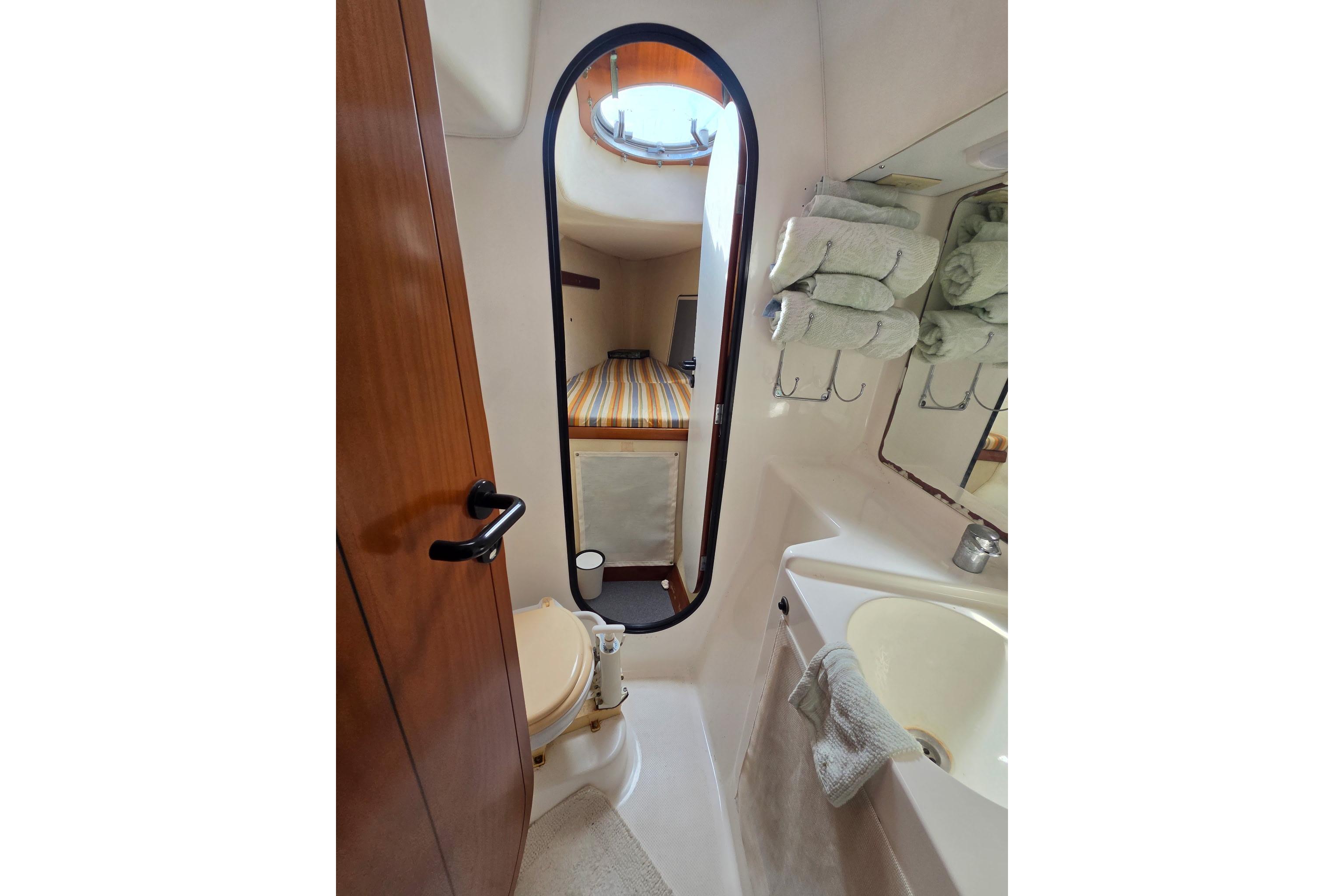 Bathroom interior of 2000 Fountaine Pajot Maryland 37 yacht, featuring sink, mirror, and towels.