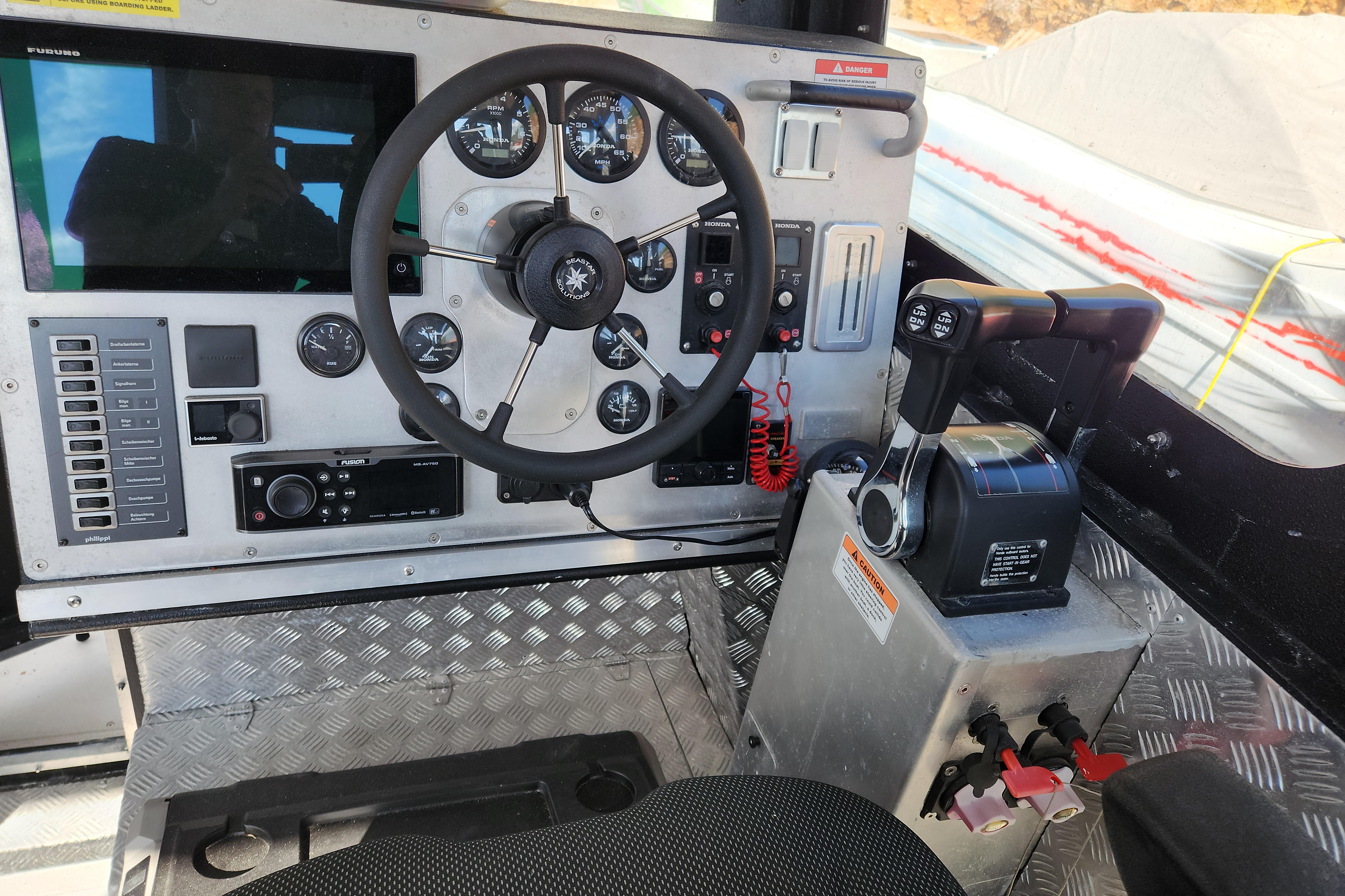 Control panel of 2018 ALUTEH LC 853 boat with steering wheel and throttle levers.