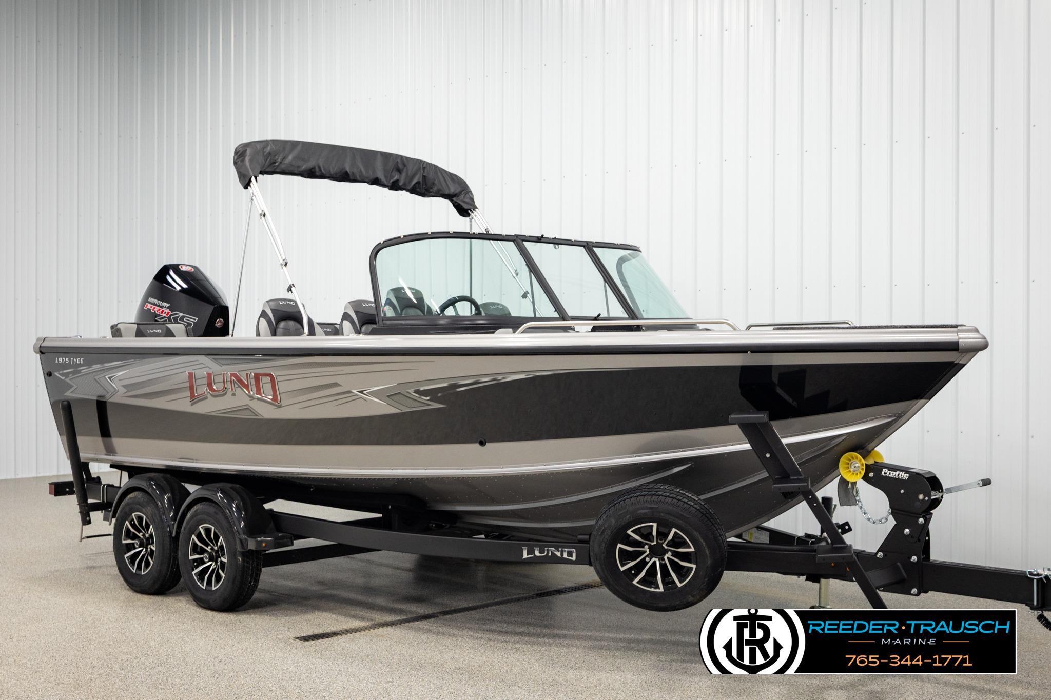 2026 Lund 1975 Tyee boat on trailer in showroom, side view.