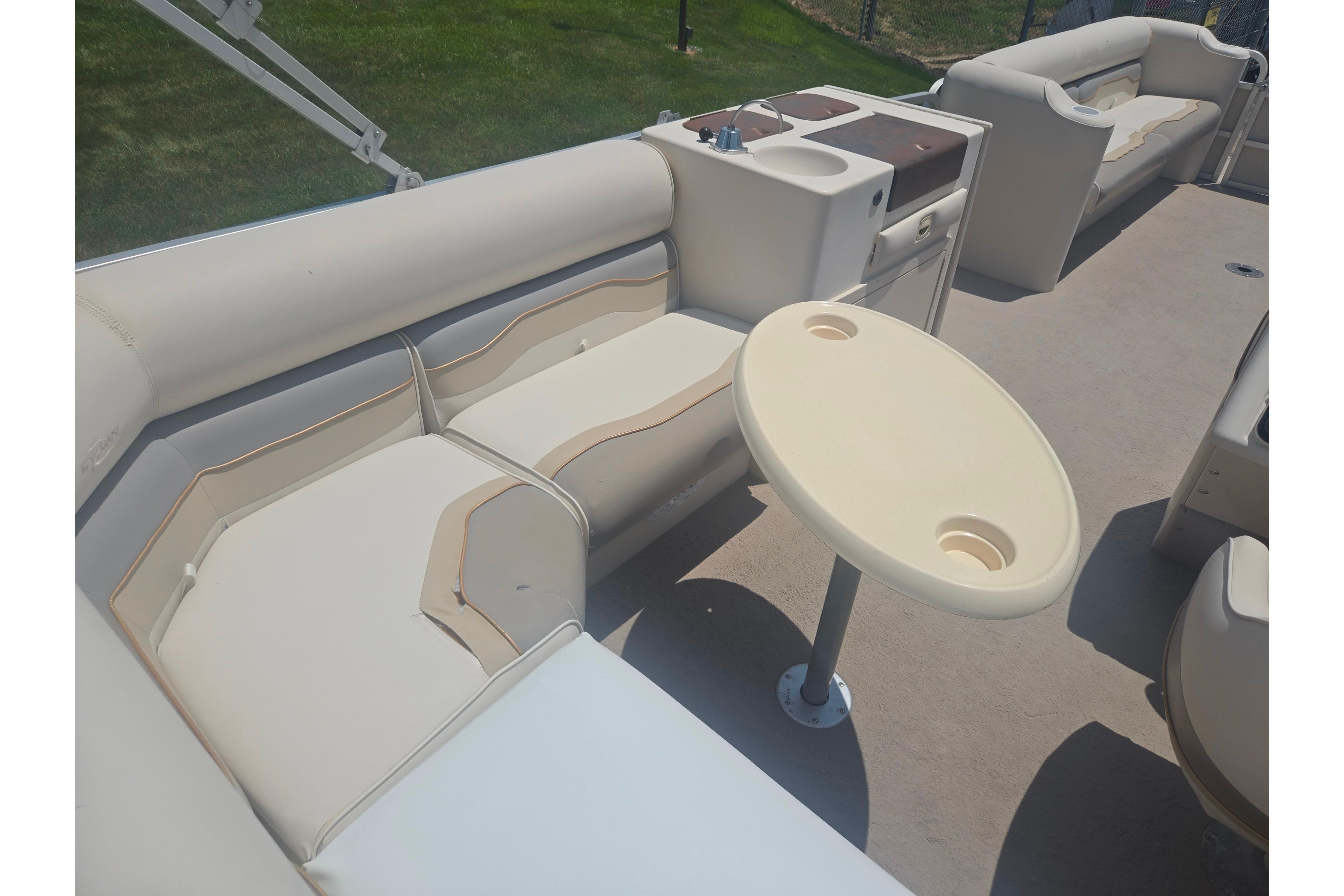2000 Sylvan 824 Elite Cruise boat interior with beige seating and oval table.