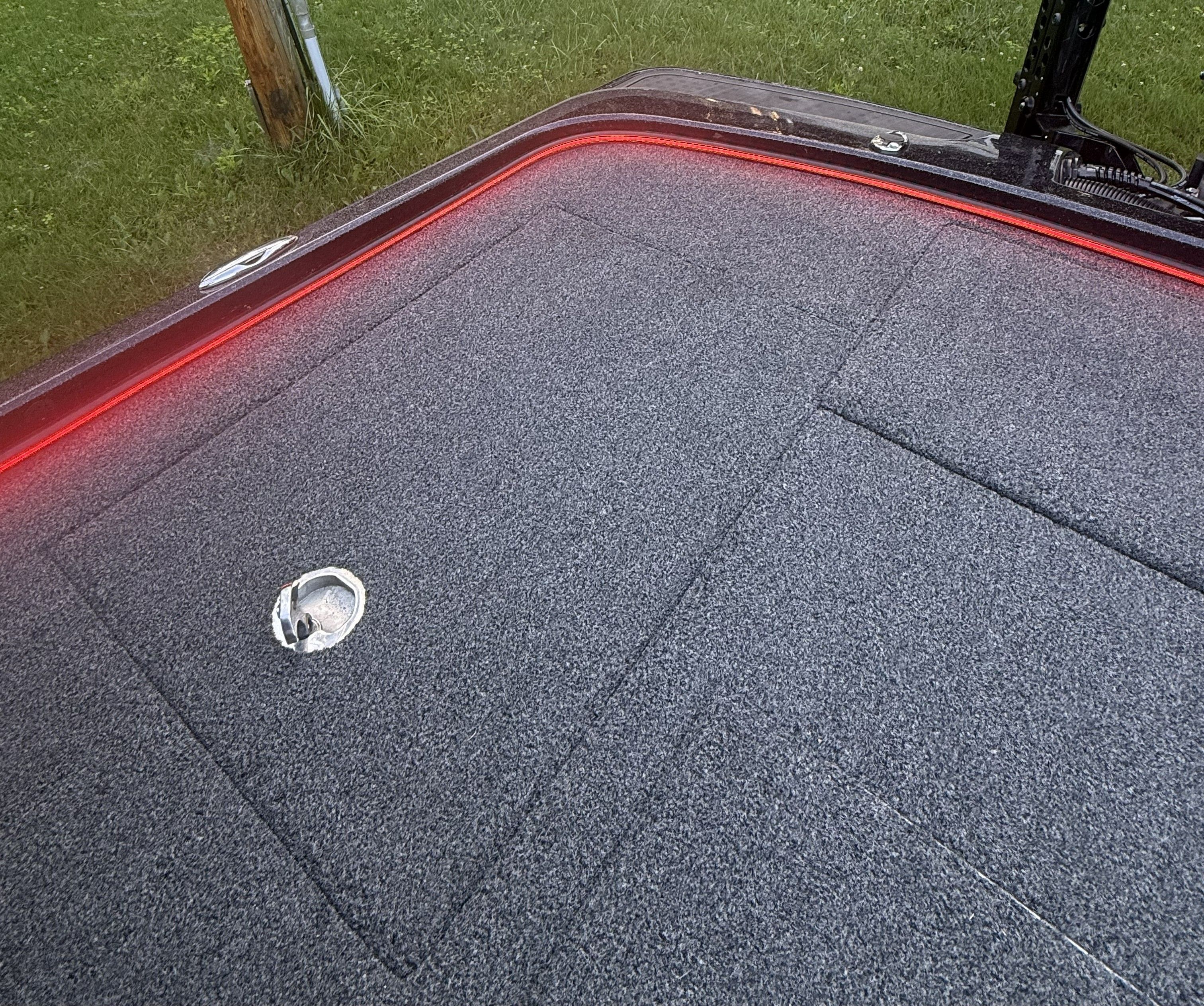 The image shows the deck of a Nitro Z21 XL Pro boat with gray carpeting and red lighting.