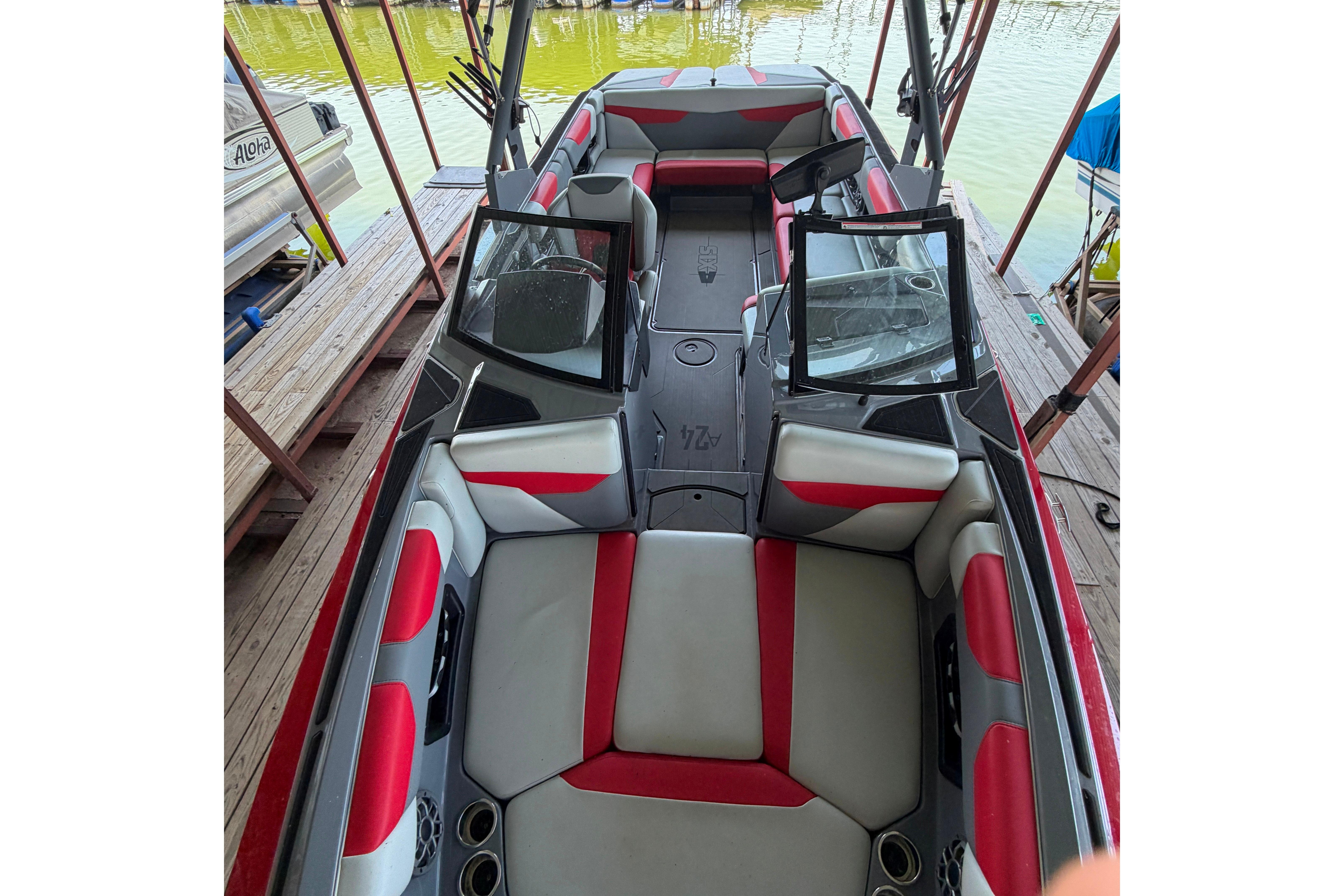 2021 Axis A24 boat interior with red and gray seating, docked by the water.
