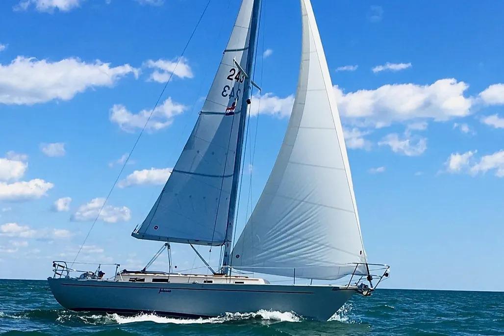 1988 Hinterholler NIAGARA 35 sailboat gliding on blue ocean under clear sky.