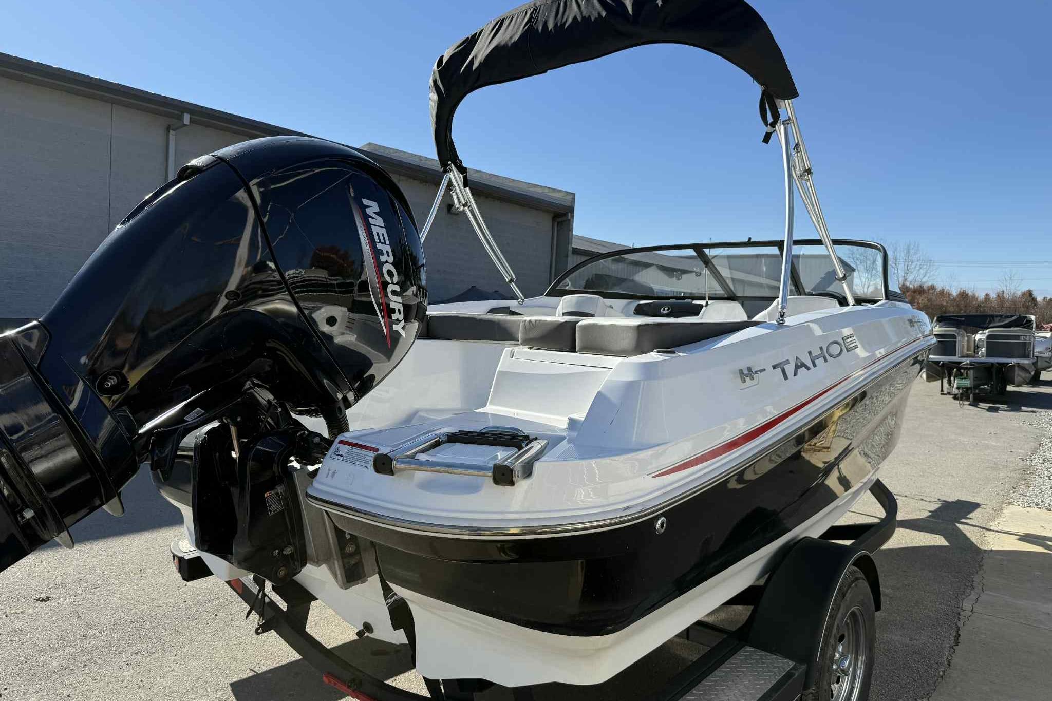 2021 Tahoe 550 TS boat with Mercury engine, parked outdoors on a sunny day.