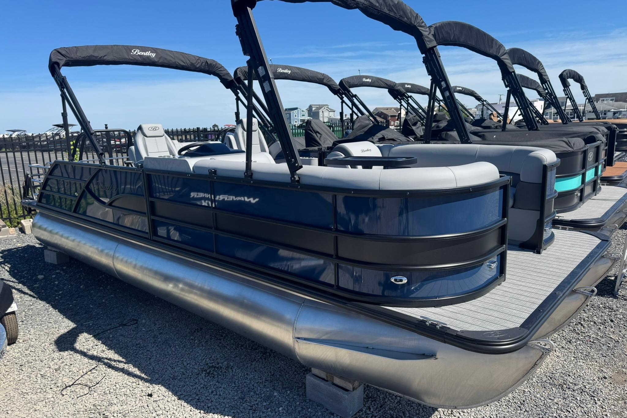 2026 Bentley Pontoons Legacy 243 Swingback, sleek design, docked under clear blue sky.
