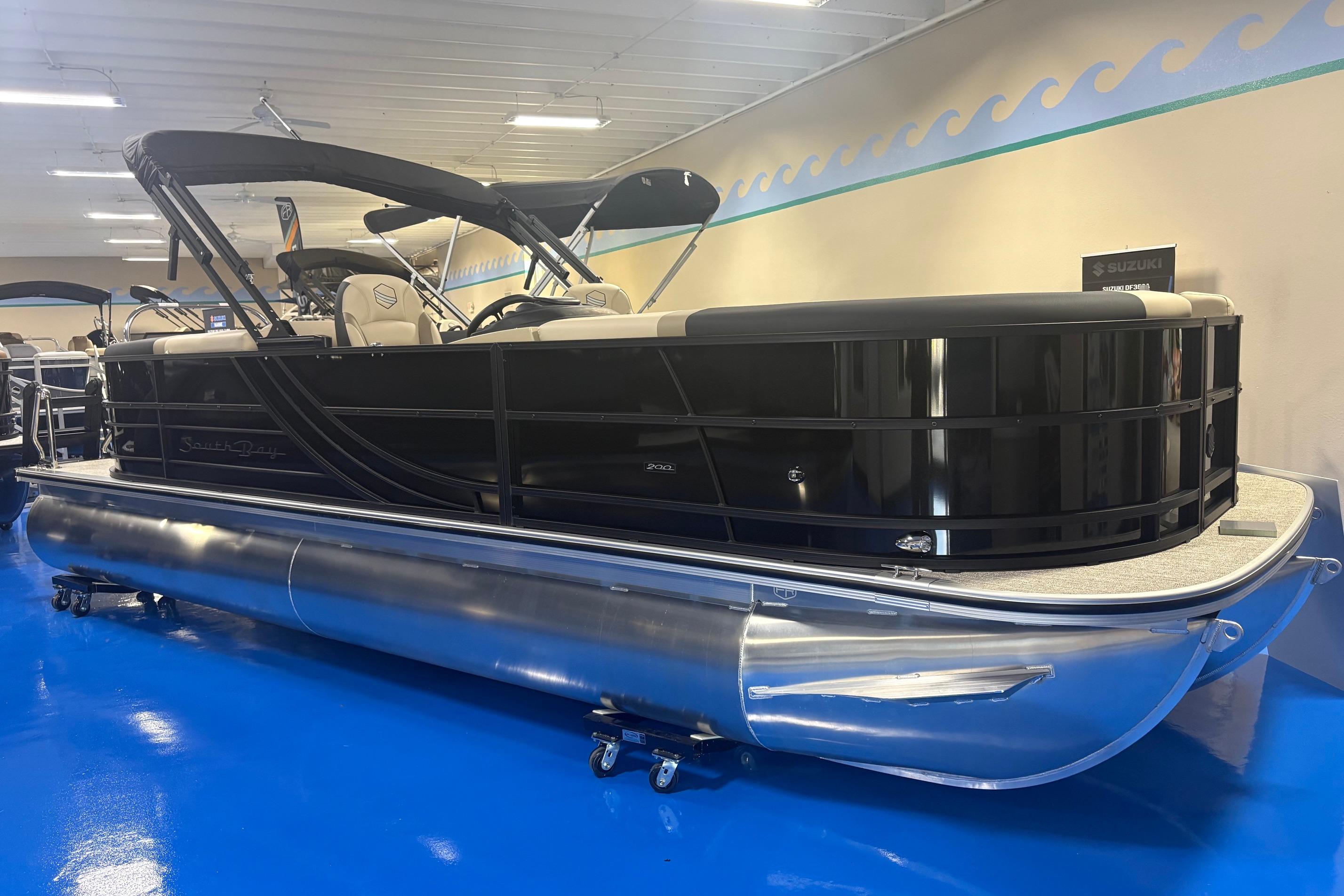 2026 South Bay S224RS pontoon boat displayed indoors on blue floor.