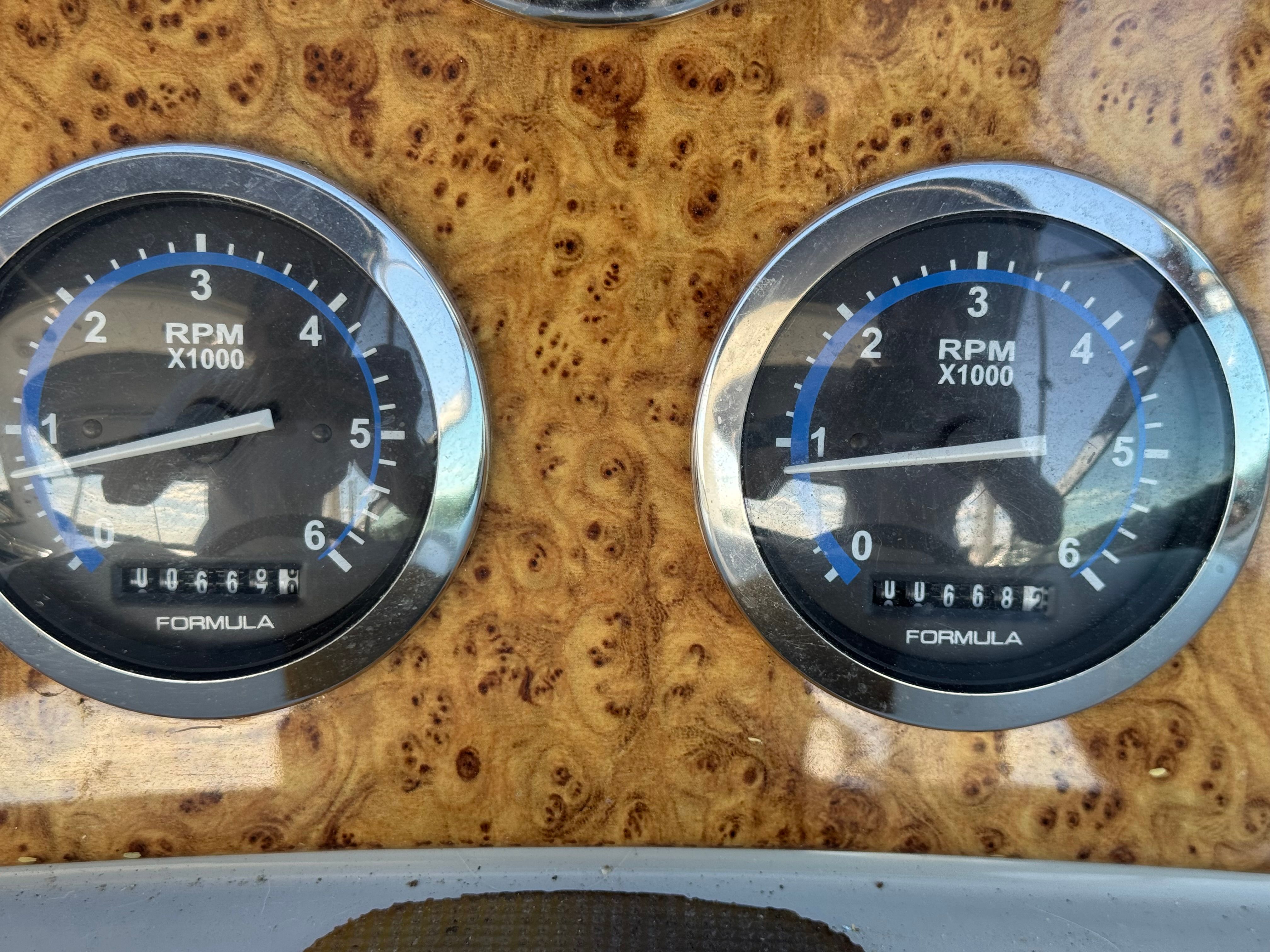 Two RPM gauges on a wooden dashboard, displaying revolutions per minute.