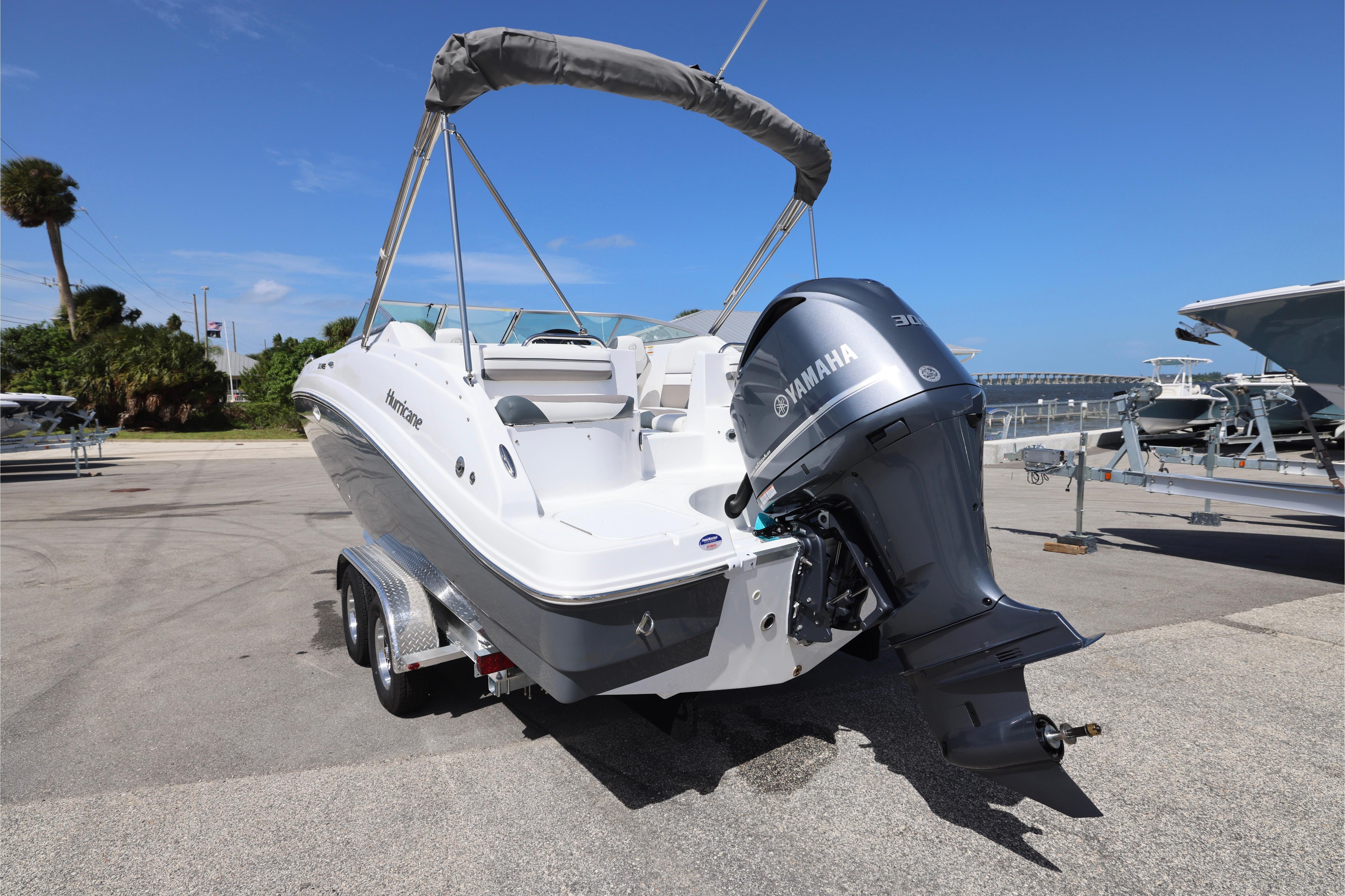 2026 Hurricane SunDeck 2486 OB boat with Yamaha engine on trailer, sunny day.