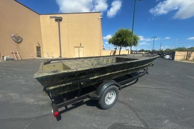 2026 Tracker Grizzly 1754 Utility boat on trailer in parking lot, sunny day.