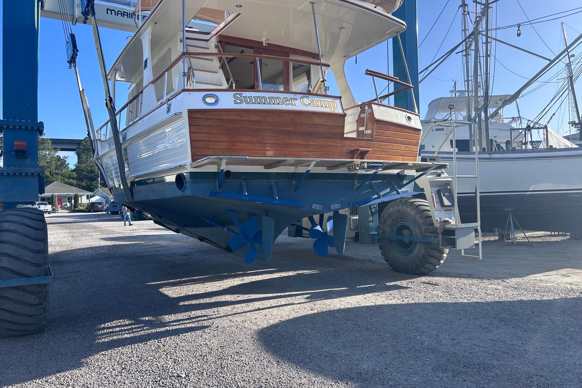 Grand Banks 42 Europa 1999 yacht lifted by marina crane for maintenance.