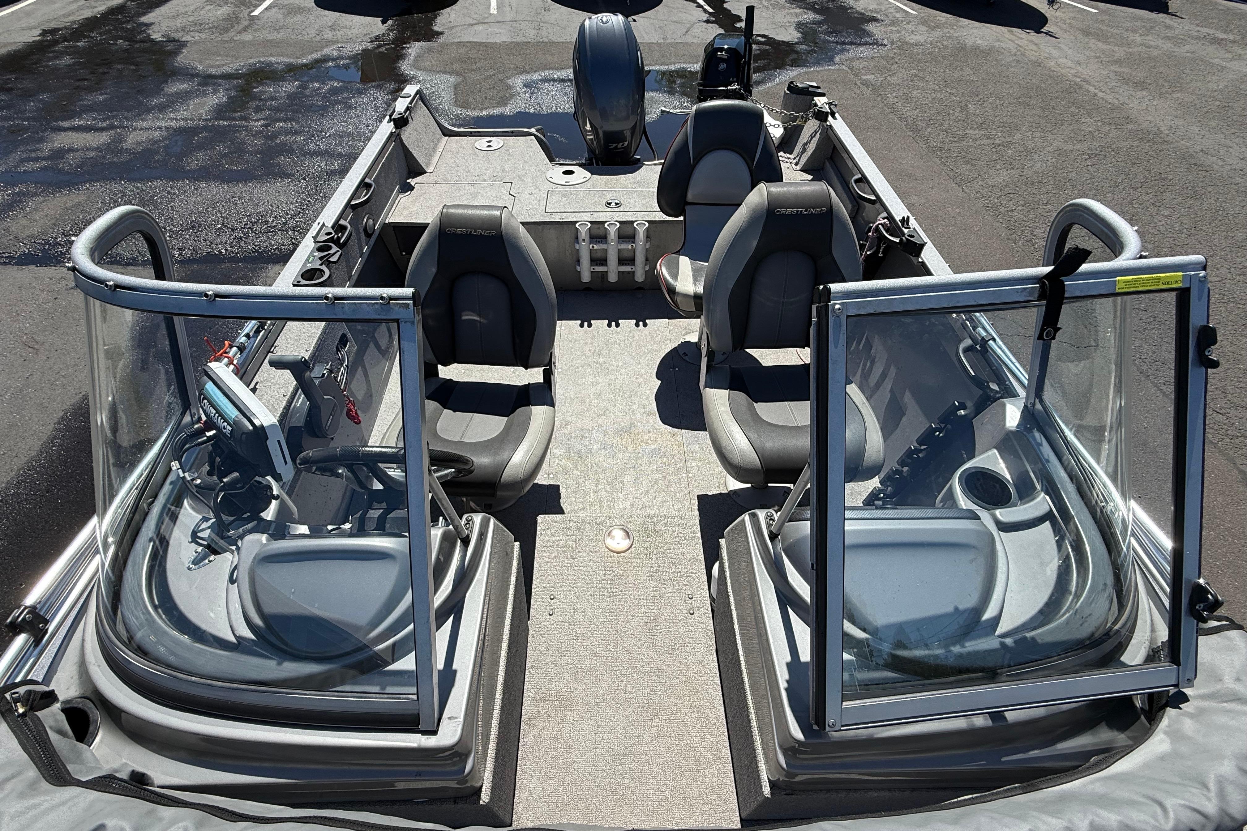 2016 Crestliner 1700 Vision boat interior with seating and windshield in a parking lot.