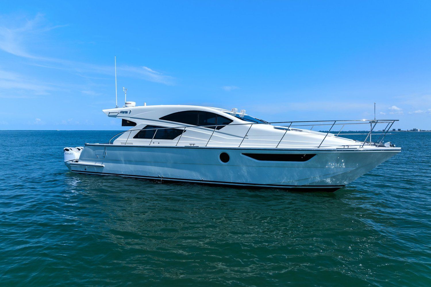A sleek, modern catamaran on calm water under a clear sky.
