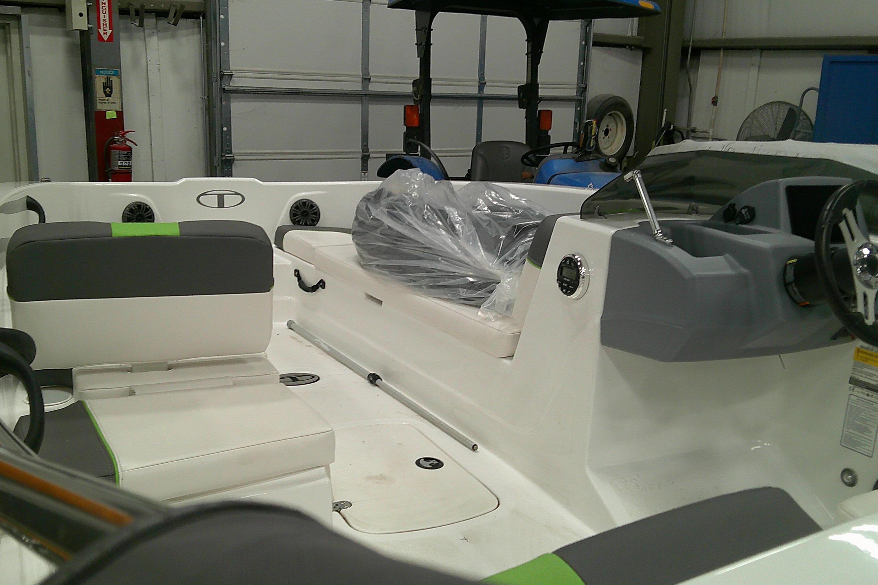 2023 Tahoe T18 boat interior with seating and steering wheel in a garage setting.
